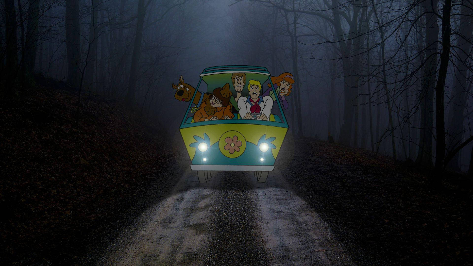 Scooby 桌布 壁紙 — 史酷比幫派乘坐他們標誌性的黃色廂型車在夜間行駛在霧氣瀰漫的森林道路上，車頭燈劃破黑暗。
