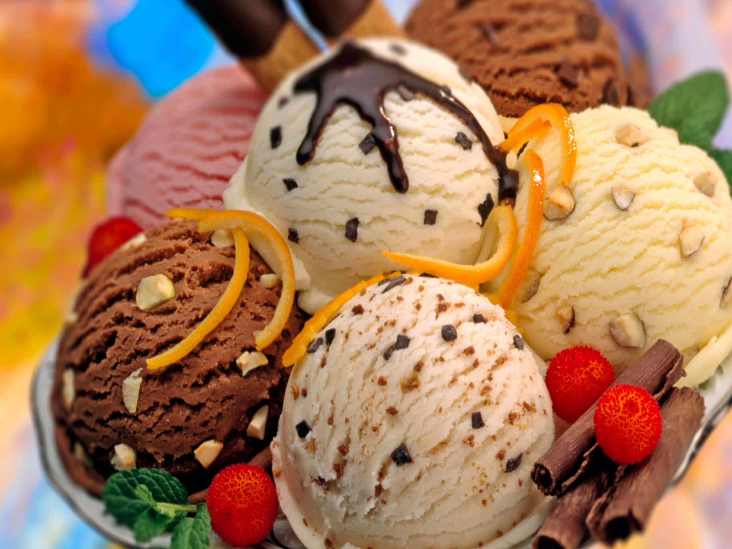 Ice Cream 桌布 壁紙 — 各種冰淇淋球的鮮豔特寫，上面淋有巧克力醬、糖漬橙皮和新鮮莓果。