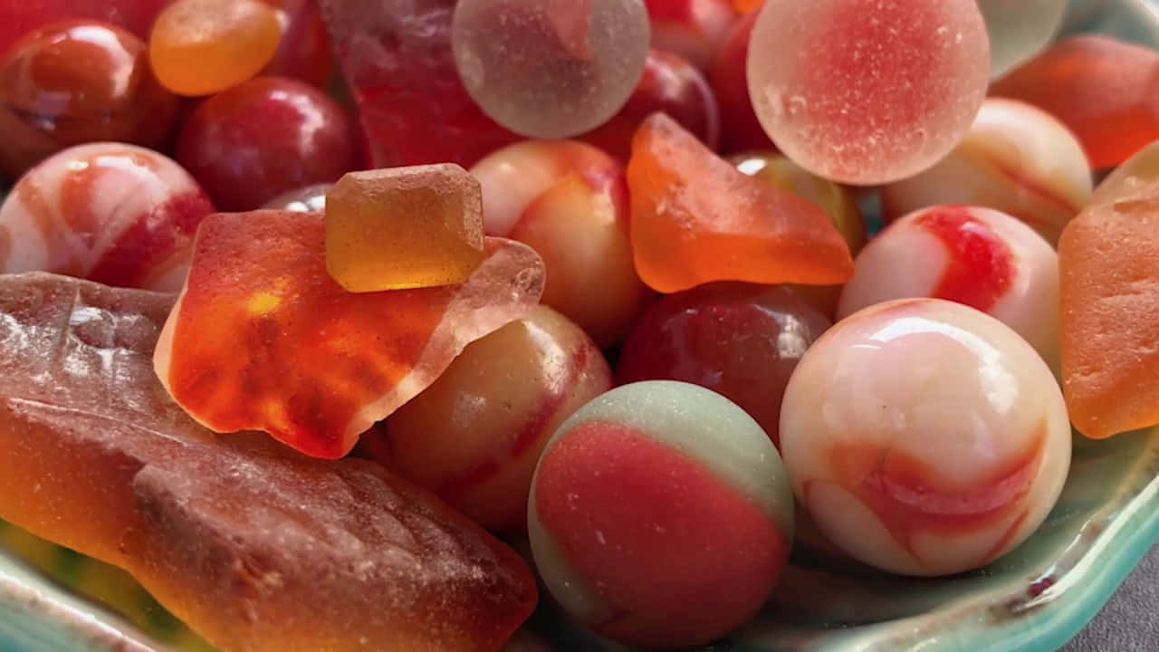 Sea Glass 桌布 壁紙 — 各種半透明軟糖的特寫，呈現鮮豔的紅色、橙色和粉紅色調，閃爍著糖晶體。