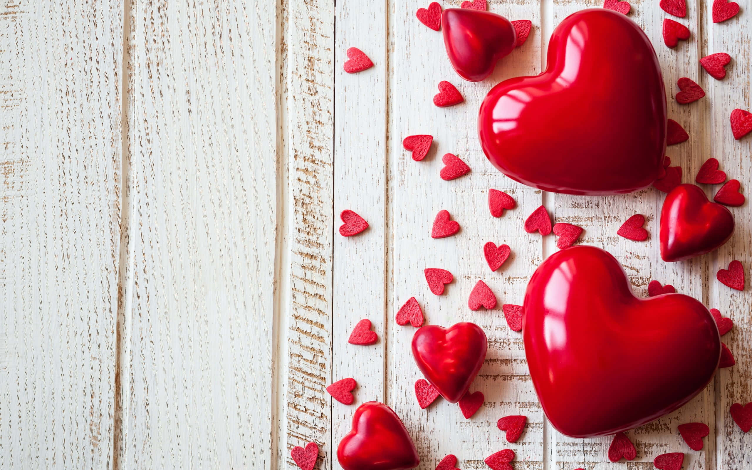 Aesthetic Heart 桌布 壁紙 — 各種尺寸的光澤紅色心形散落在風化的白色木質表面上。