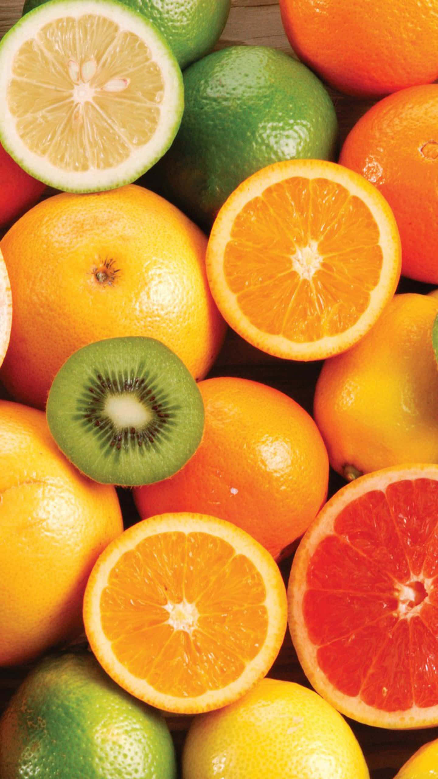 Refreshing 桌布 壁紙 — 各種柑橘類水果（包括柳橙、萊姆和奇異果）的鮮豔特寫，其中一些切片露出多汁的內部。