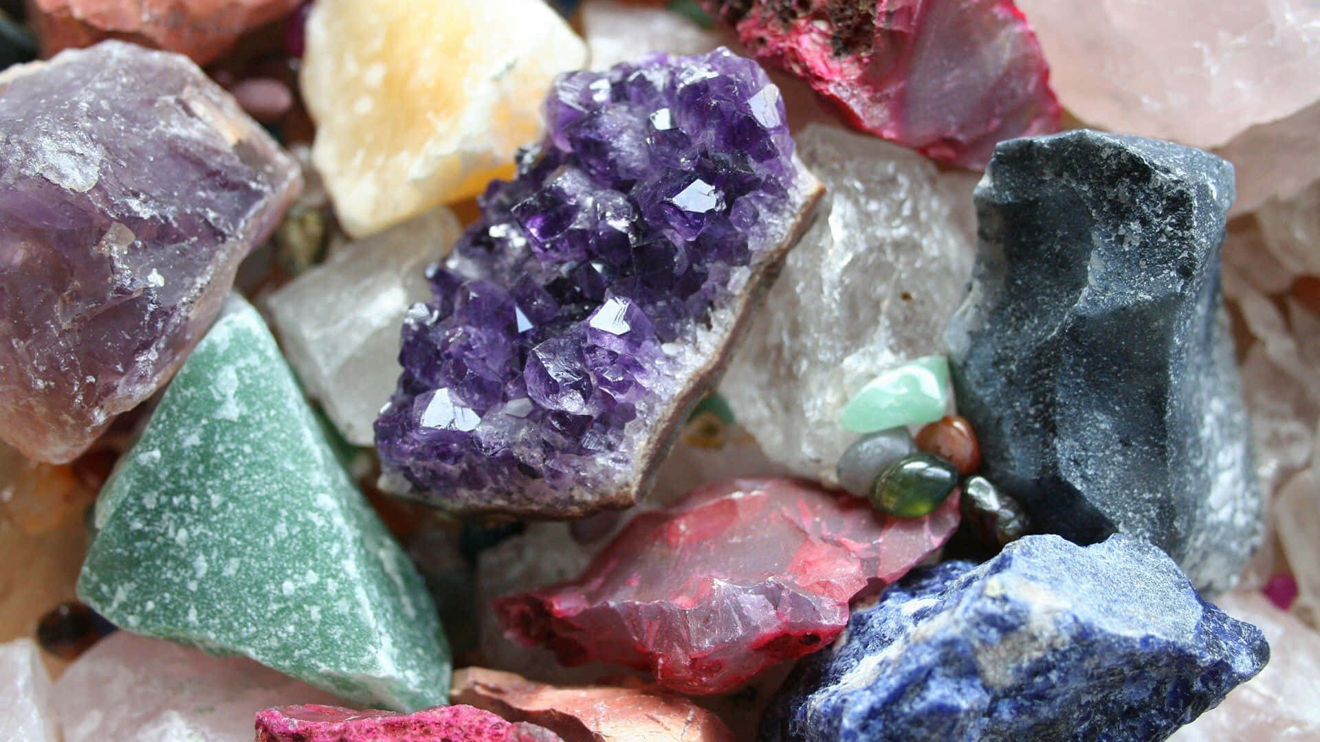 crystals 桌布 壁紙 — 各種粗糙寶石和晶體的鮮豔特寫，包括紫色紫水晶、綠色東陵石和深藍色青金石。
