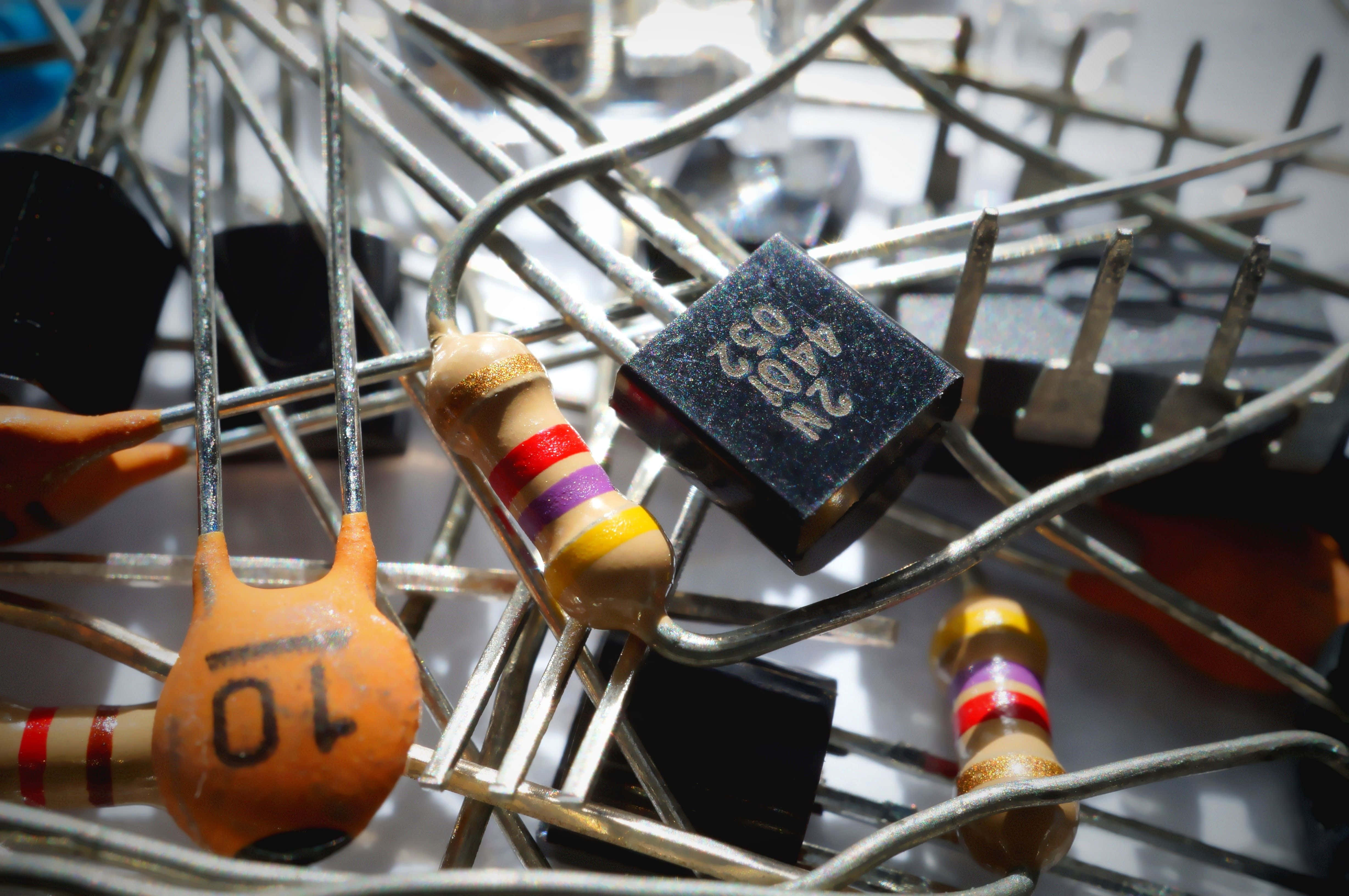 Electronic Components 桌布 壁紙 — 各種電子電阻器和電線纏繞在混亂的電路板廢料堆中的特寫。