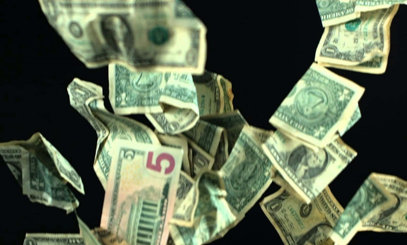 Falling Money 桌布 壁紙 — 各種面額的美元鈔票在純黑背景上動態地層層疊落。