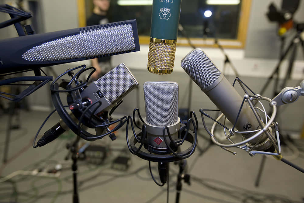 Microphones 桌布 壁紙 — 各種風格的專業錄音室麥克風安裝在支架上，背景有電線和設備。