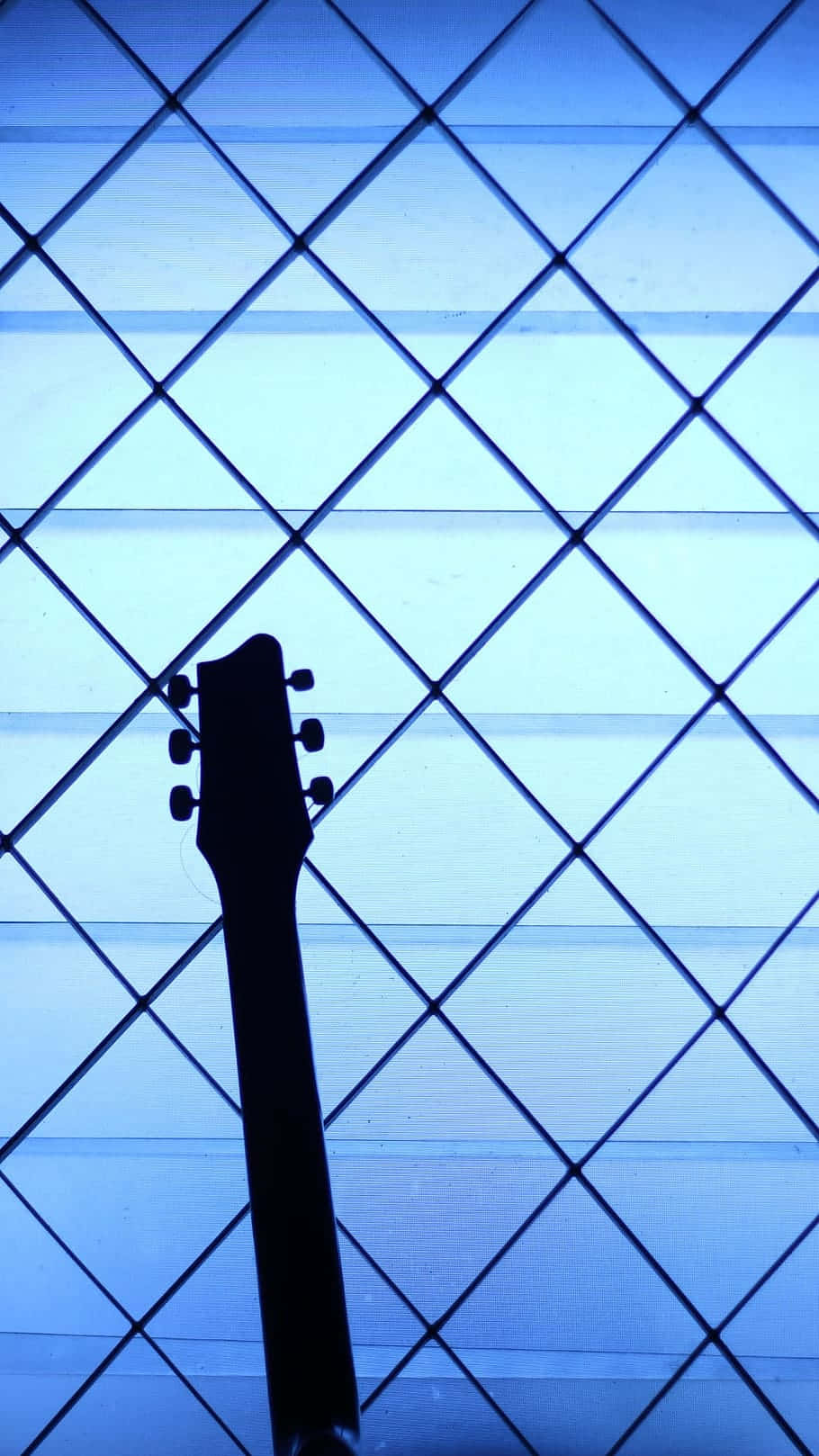 Guitar Aesthetic 桌布 壁紙 — 吉他琴頭剪影，襯以藍色菱形圖案窗格。