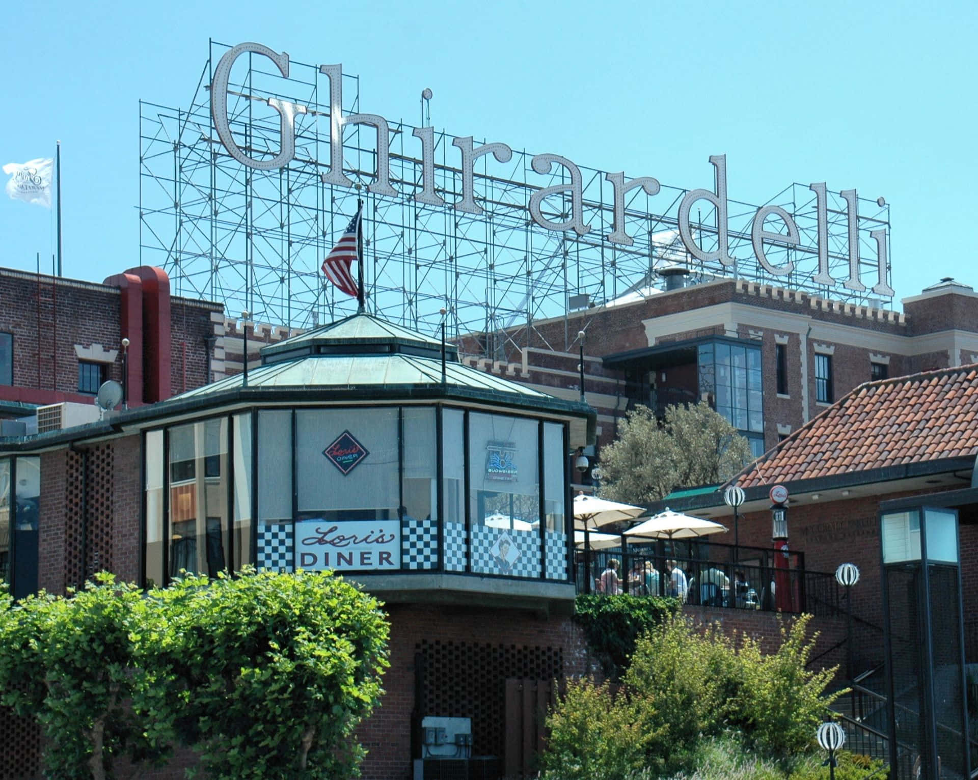 加州 桌布 壁紙 — 吉拉德里廣場陽光明媚的一天景色，前景是Leris Diner，標誌性招牌聳立在磚砌建築和綠植之上。