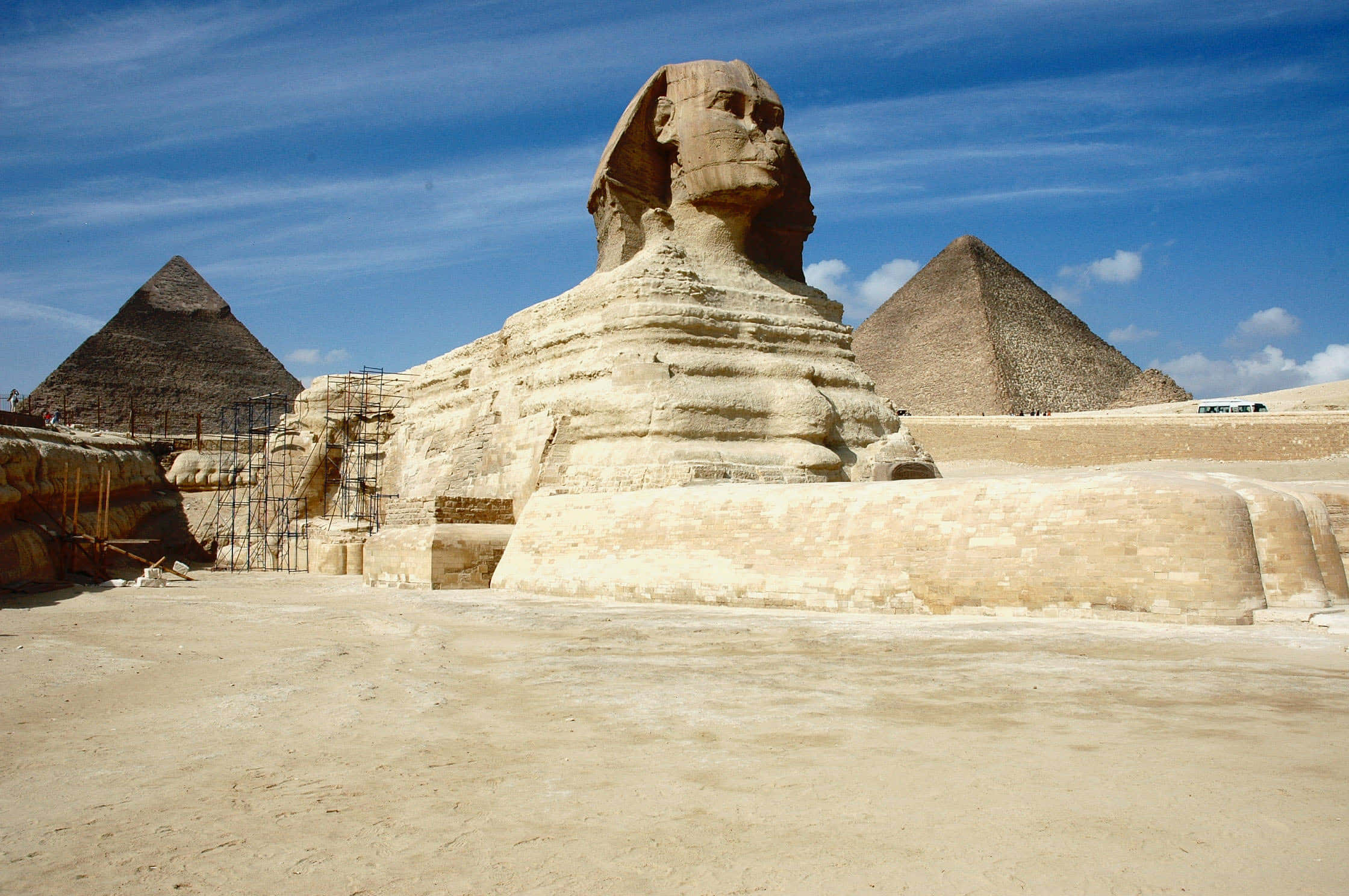 pyramid 桌布 壁紙 — 吉薩大獅身人面像在明亮的藍天下雄偉地矗立，背景是金字塔。