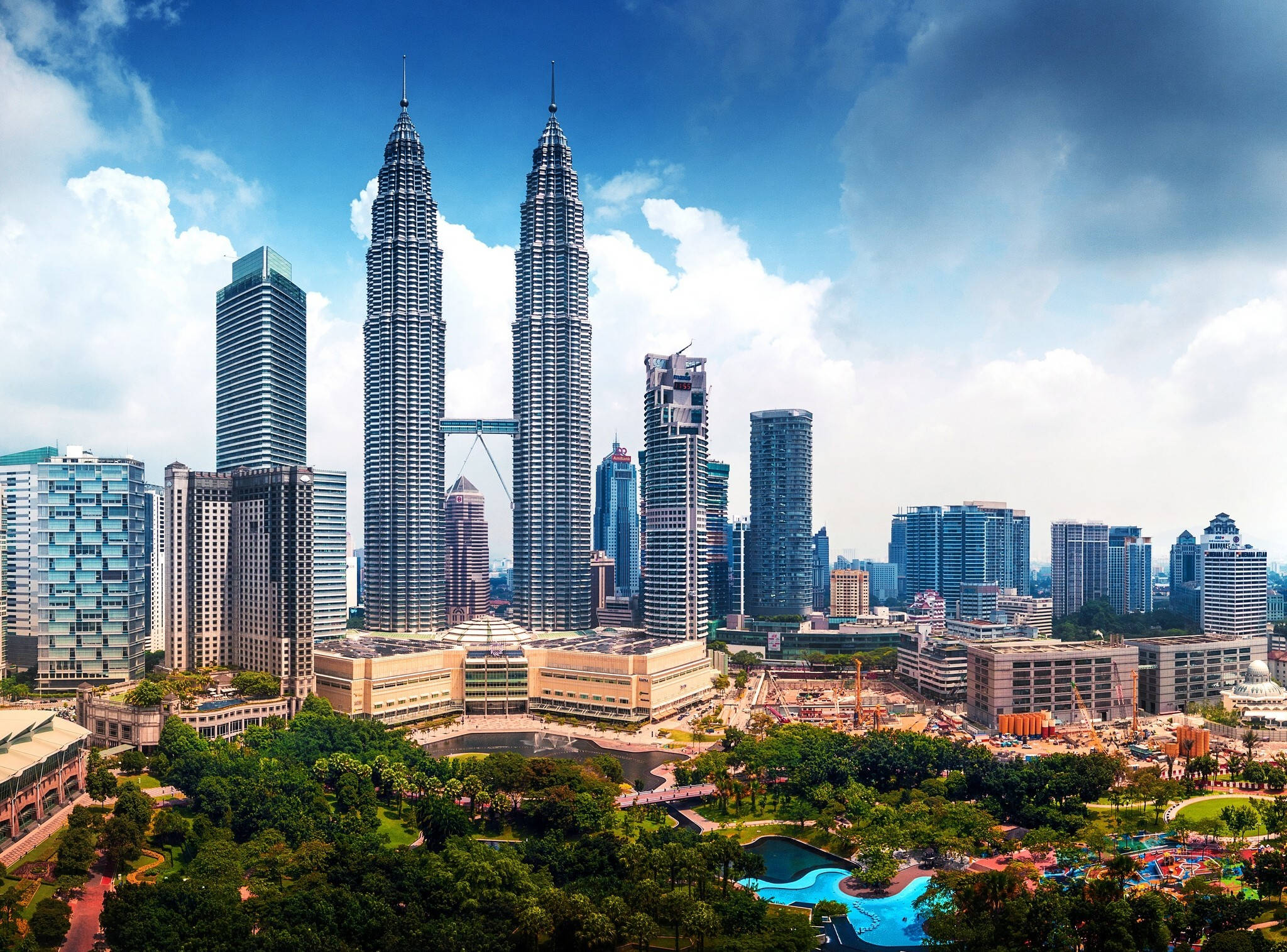 Malaysia 桌布 壁紙 — 吉隆坡天際線的鳥瞰圖，以標誌性的雙峰塔為主，在明亮的藍天白雲下。