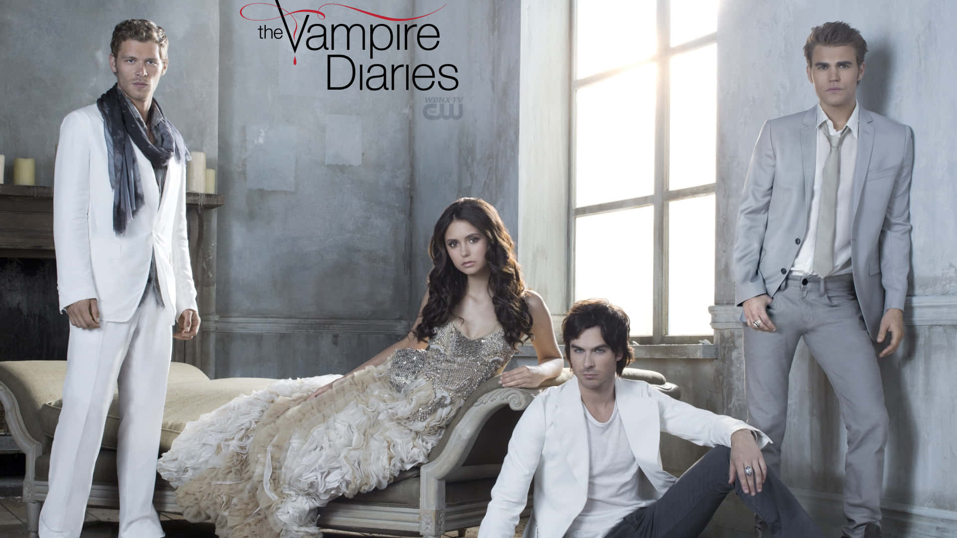 Vampire Diaries Desktop 桌布 壁紙 — 《吸血鬼日記》的四位演員在陽光照射的灰色房間中，與復古家具和蠟燭一起戲劇性地擺姿勢。