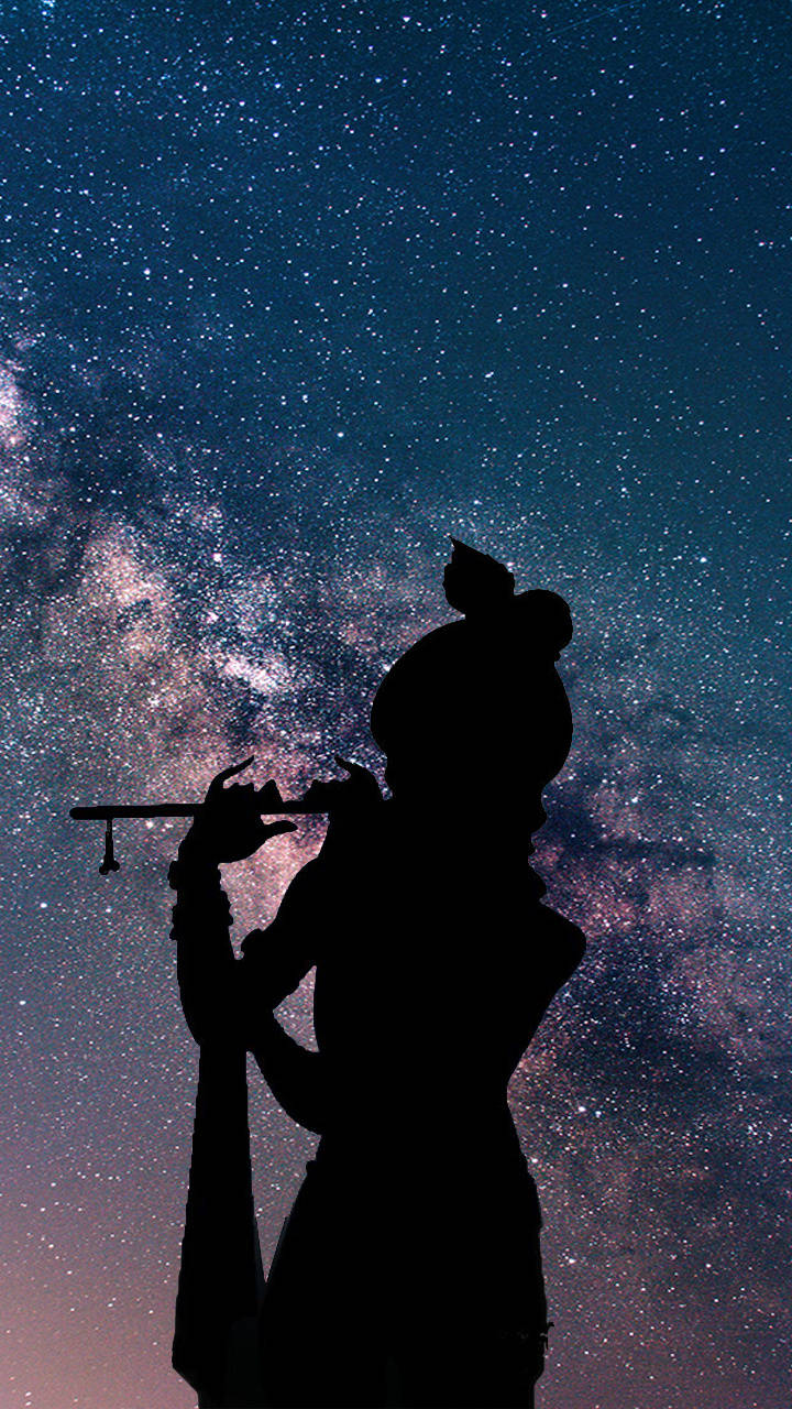 krishna iPhone 桌布 壁紙 — 吹笛者的剪影，背景是充滿活力的星空夜空，銀河在後方閃耀。