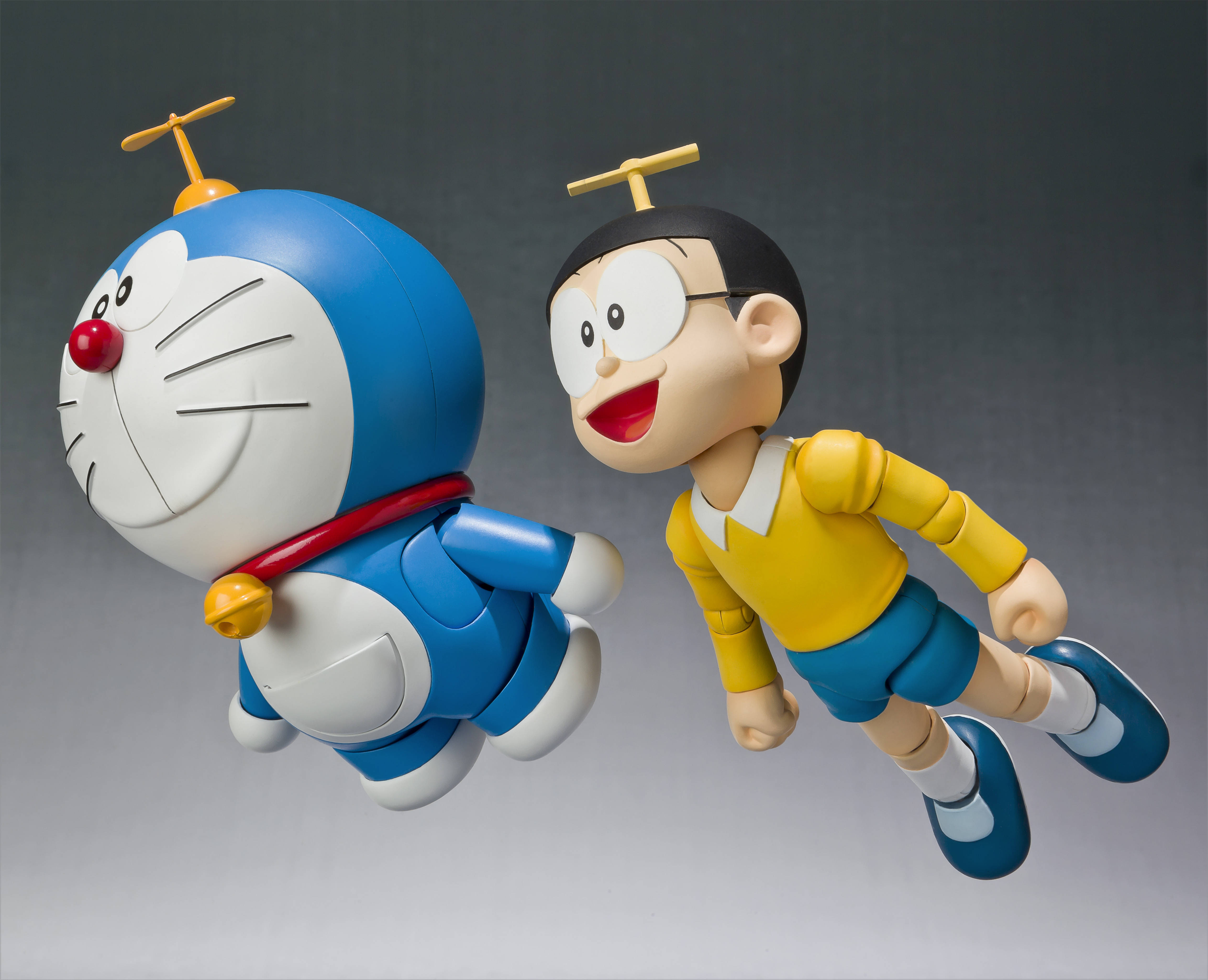 Doraemon 桌布 壁紙 — 哆啦A夢和大雄頭頂小型直升機螺旋槳，帶著愉快表情在空中飛翔。