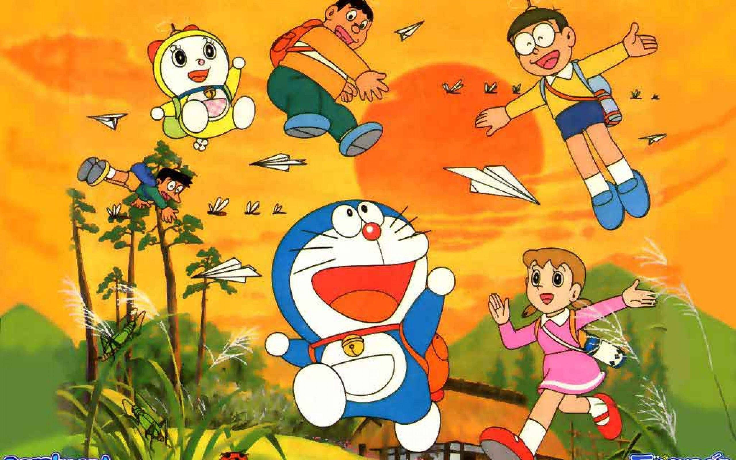 Doraemon 桌布 壁紙 — 哆啦A夢和朋友們在紙飛機上，歡樂地飛翔在綠色山丘上充滿活力的日落天空。