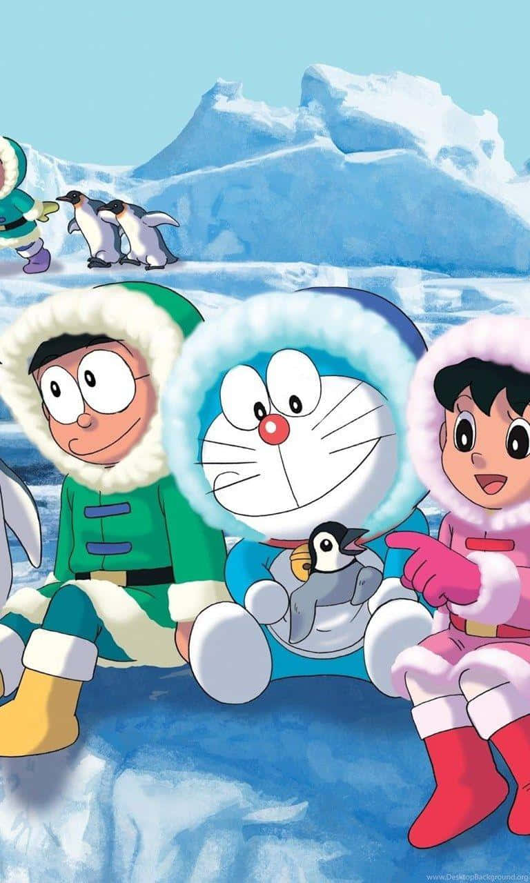 Doraemon 桌布 壁紙 — 哆啦A夢和朋友們穿著冬季裝備坐在冰上，與企鵝一起，背景是雪山和清澈的藍天。