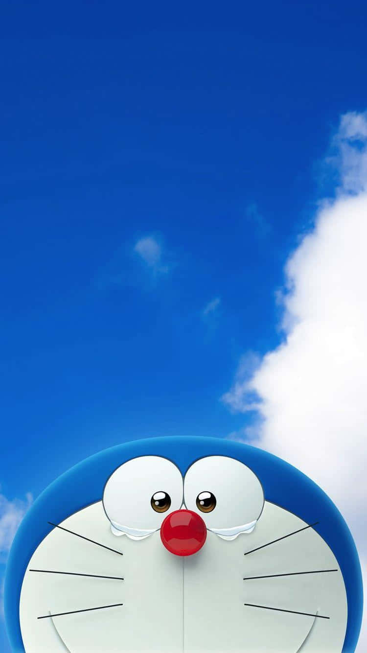 Doraemon 桌布 壁紙 — 哆啦A夢圓圓的藍色頭部從明亮的藍天和蓬鬆的白雲下方探出。