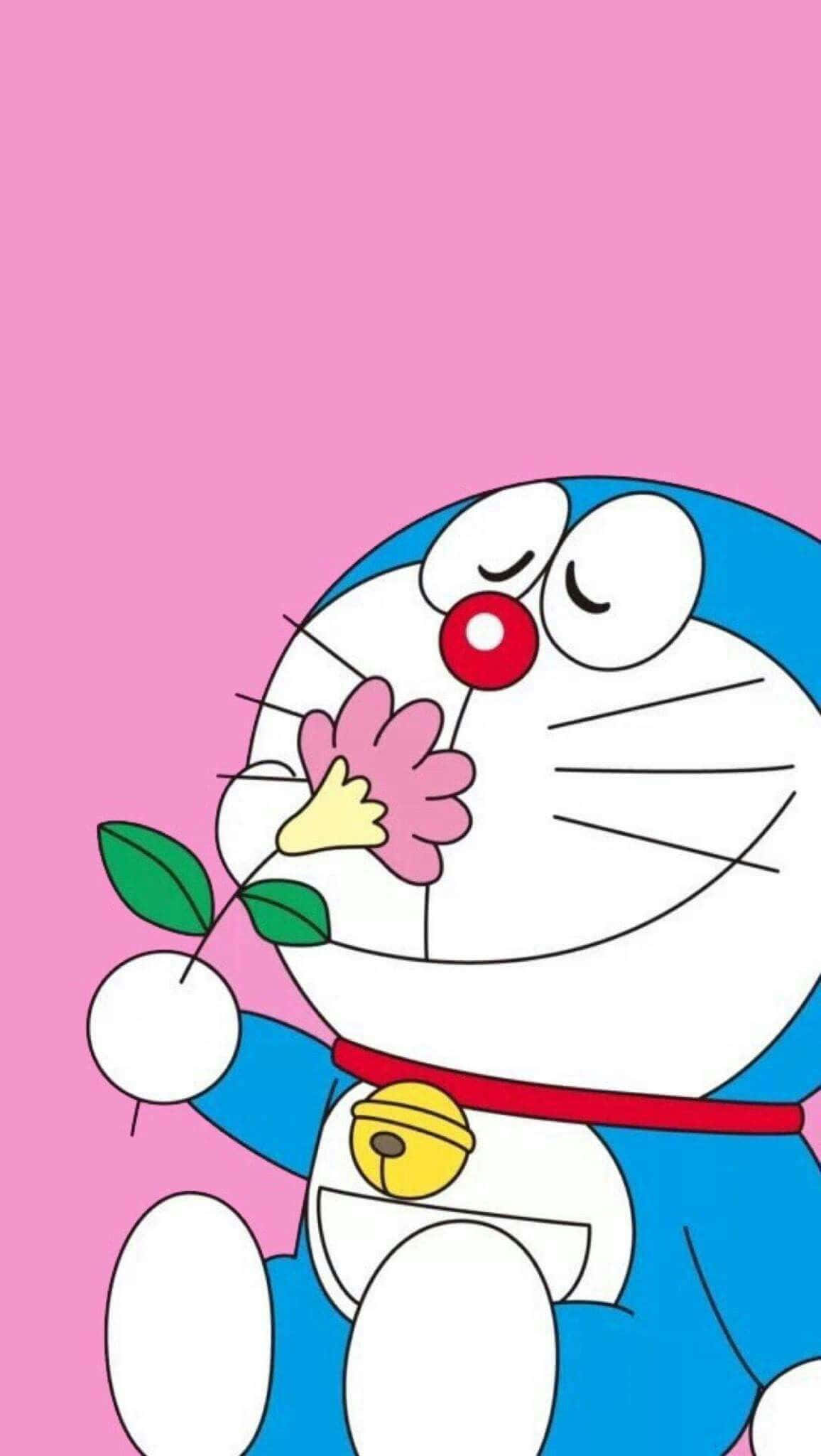 Doraemon 桌布 壁紙 — 哆啦A夢在柔和的粉紅色背景前，溫柔地微笑著拿著一朵粉紅色的花。