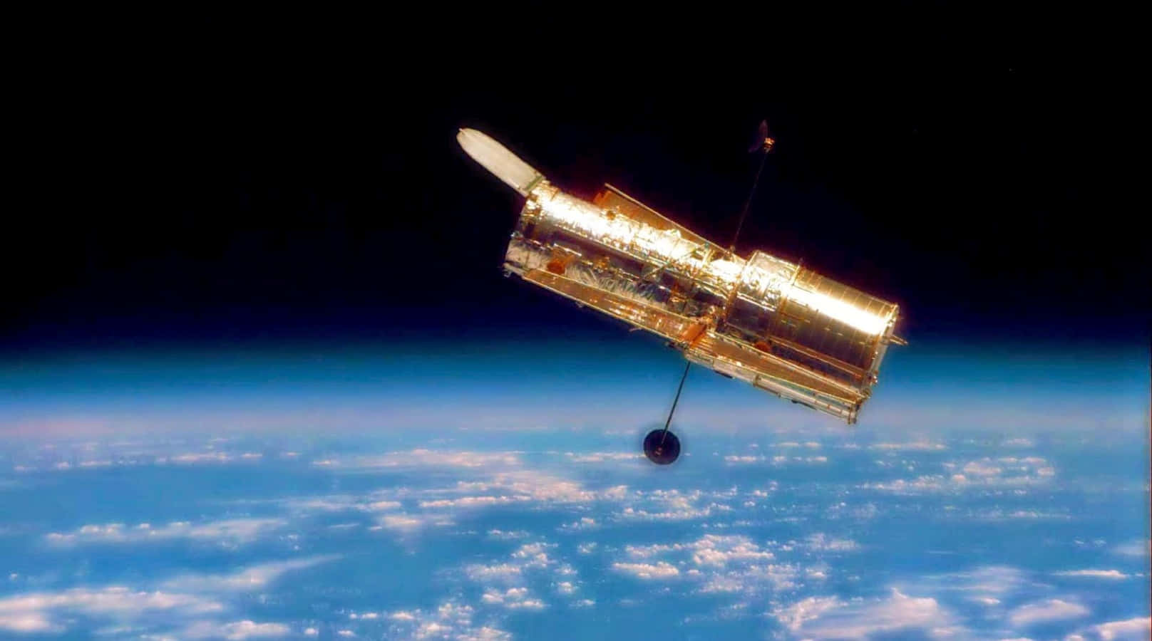 Hubble Space Telescope 桌布 壁紙 — 哈伯太空望遠鏡在太空的黑暗中，以金色光芒映襯著地球藍白相間的雲層曲線。