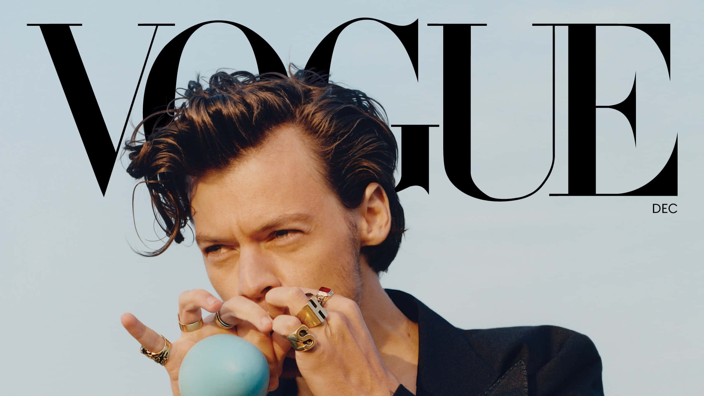 Harry Styles Laptop 桌布 壁紙 — 哈利·史泰爾斯手持藍色球體和多個戒指，以Vogue雜誌封面為背景，凝視著鏡頭。