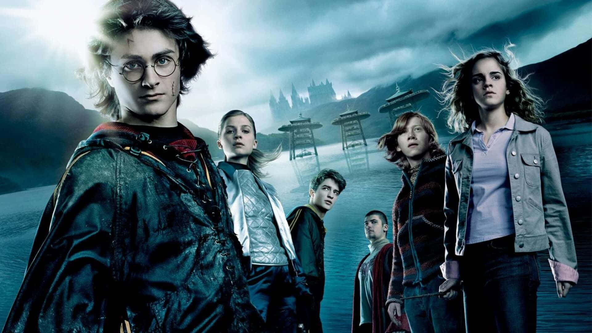 Harry Potter All Characters 桌布 壁紙 — 哈利波特和朋友們在暴風雨的天空和霧氣瀰漫的水面下，堅定地站在霍格華茲城堡前。