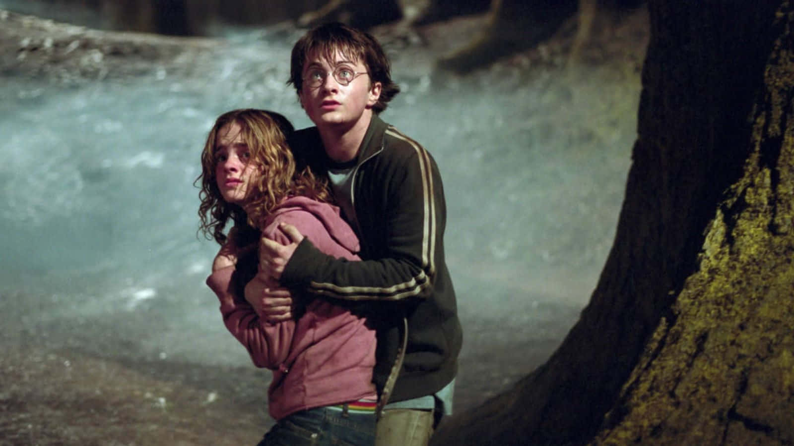 The Prisoner Of Azkaban 桌布 壁紙 — 哈利波特在森林中霧氣瀰漫的瀑布附近保護性地抱著妙麗格蘭傑。