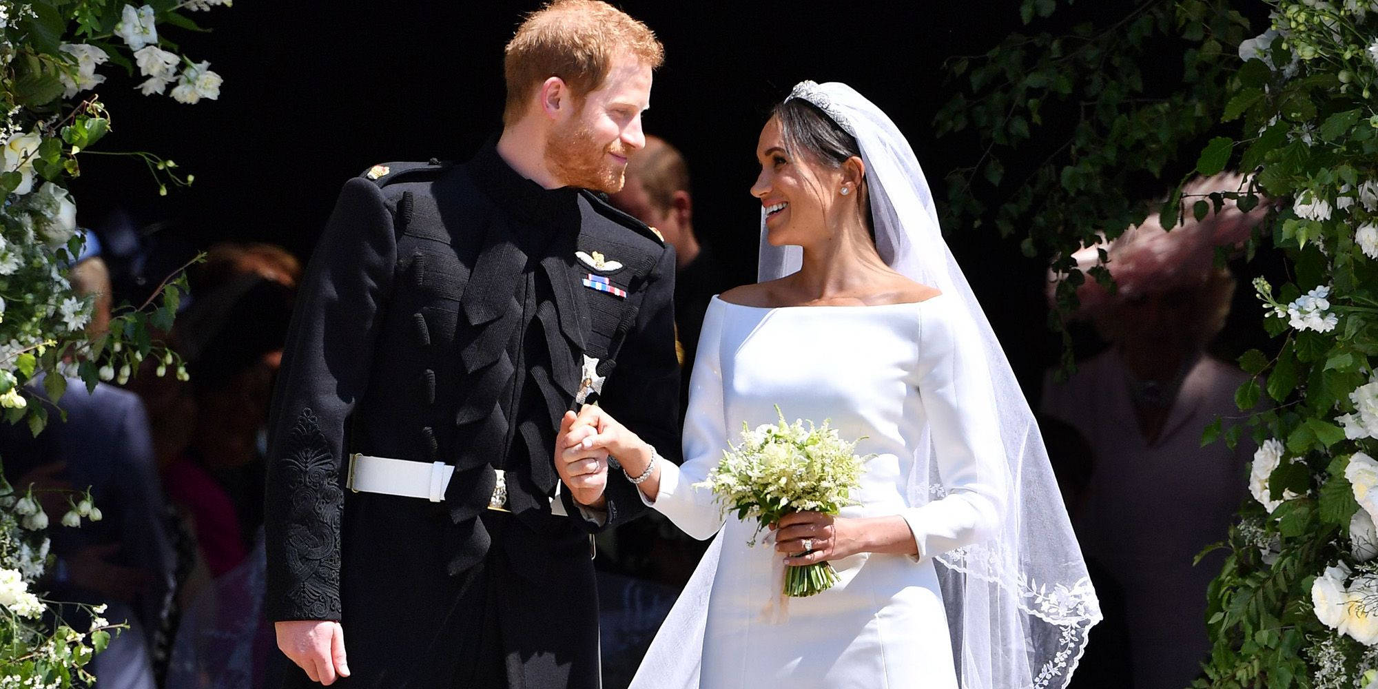 Meghan Markle 桌布 壁紙 — 哈利王子和梅根·馬克爾在婚禮上於花拱門下牽手微笑，神情溫暖。