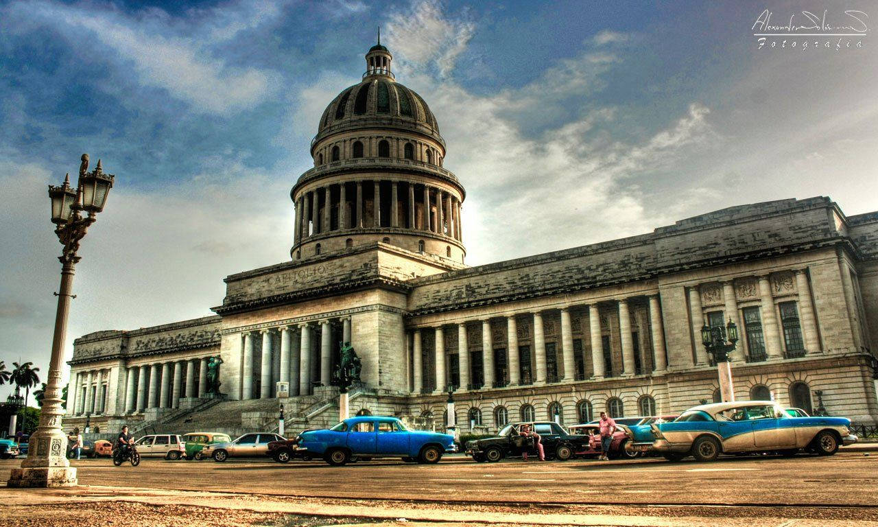 Cuba 桌布 壁紙 — 哈瓦那宏偉的新古典主義國會大廈，前面停著復古汽車，天空多雲而戲劇化。