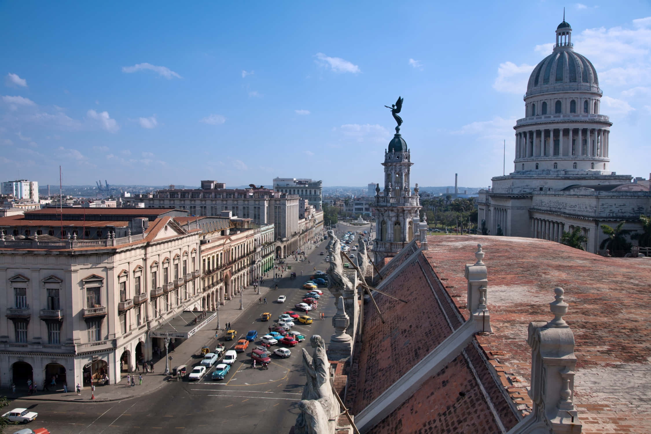 Cuba 桌布 壁紙 — 哈瓦那歷史街道的鳥瞰圖，色彩繽紛的汽車在明亮的藍天下穿梭，國會大廈建築格外突出。