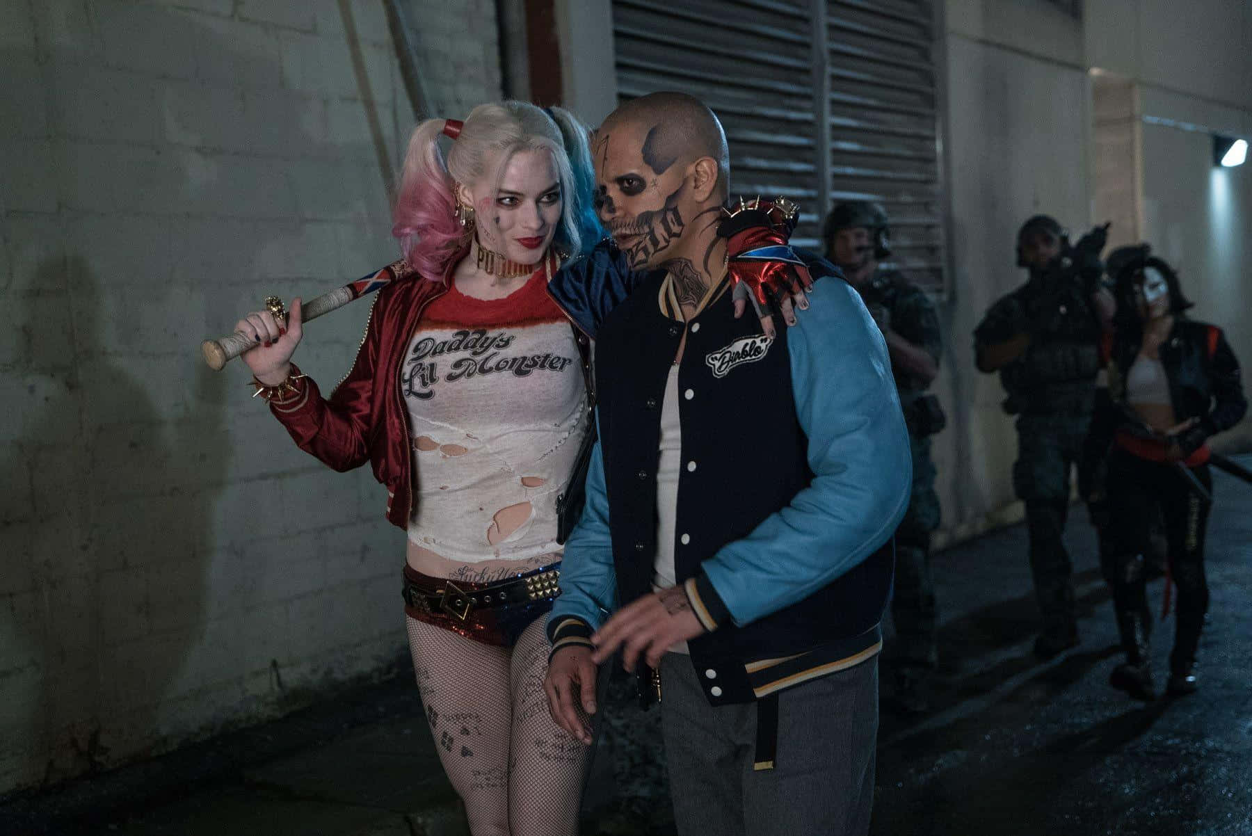 The Suicide Squad 桌布 壁紙 — 哈莉·奎茵和小丑在昏暗的小巷中緊密站立，背景有持槍人物。