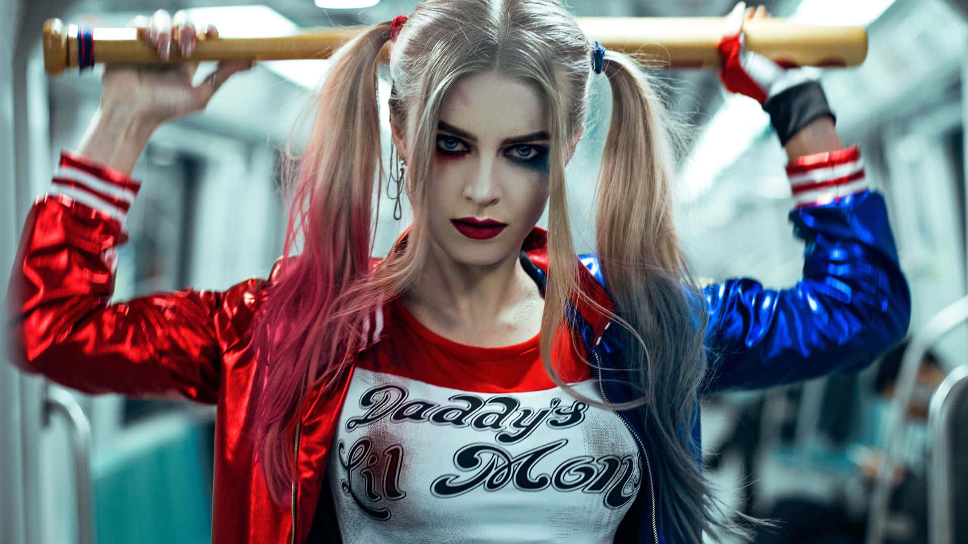 Harley Quinn Baseball Bat 桌布 壁紙 — 哈莉·奎茵在地鐵車廂內手持棒球棍，身穿標誌性的紅藍外套和「Daddy's Lil Monster」T恤。