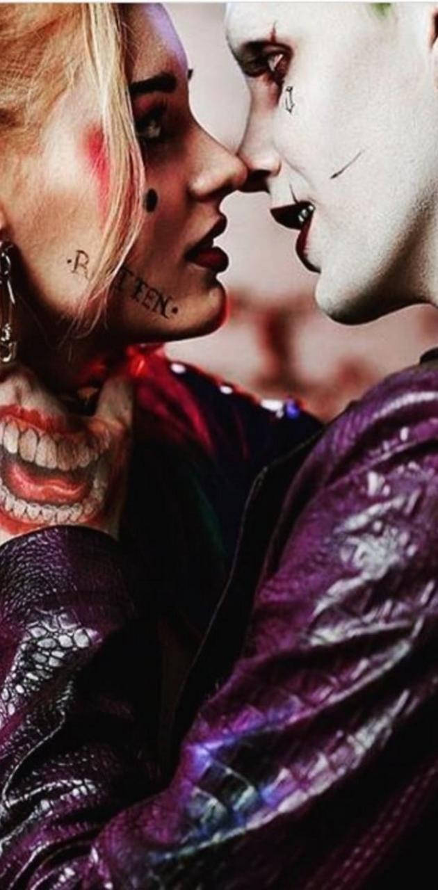Harley Quinn Phone 桌布 壁紙 — 哈莉·奎茵與小丑以鮮豔妝容和紫色皮夾克近距離親密對視。