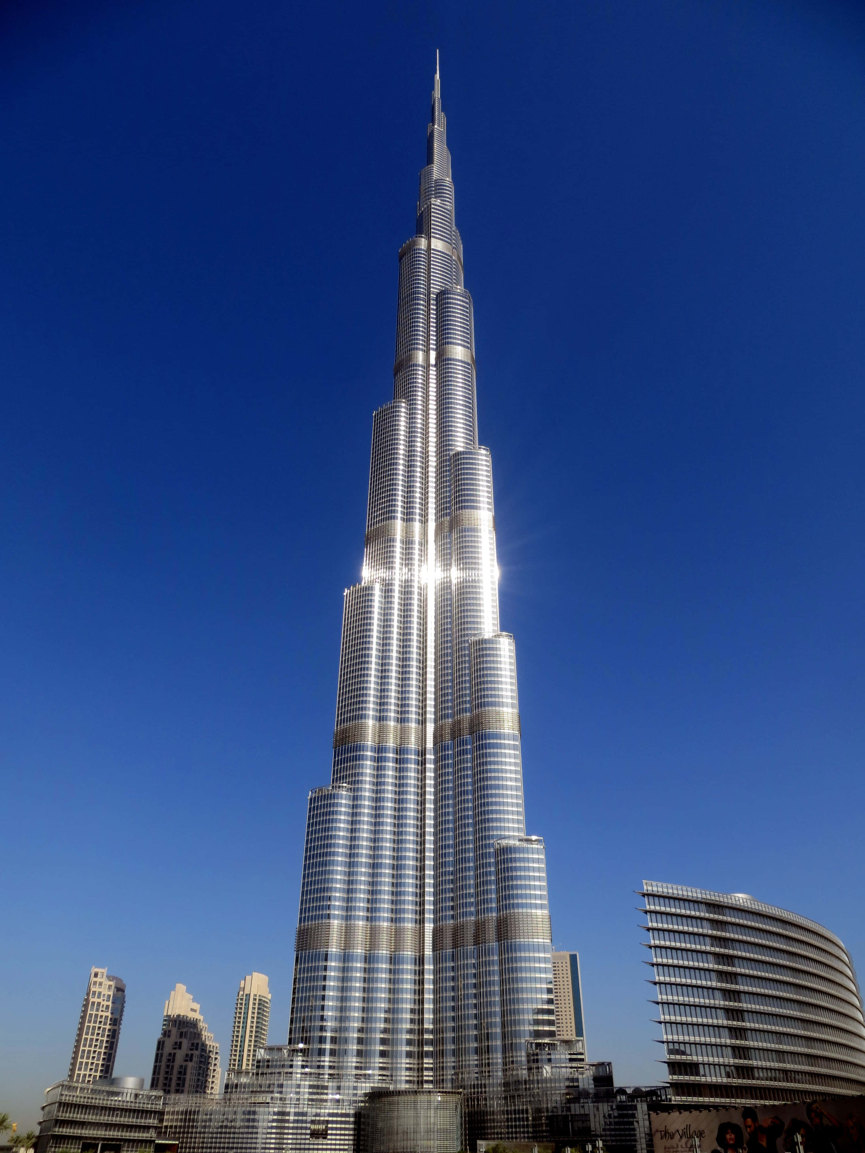 Burj Khalifa 桌布 壁紙 — 哈里發塔在晴朗的藍天下雄偉地聳立，陽光在其玻璃外牆上閃爍。