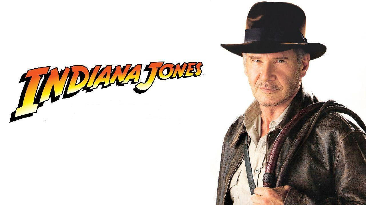 Indiana Jones 桌布 壁紙 — 哈里遜福特飾演印第安納瓊斯，戴上標誌性的費多拉帽和皮夾克，在白色背景前手持鞭子，並附有電影標題。