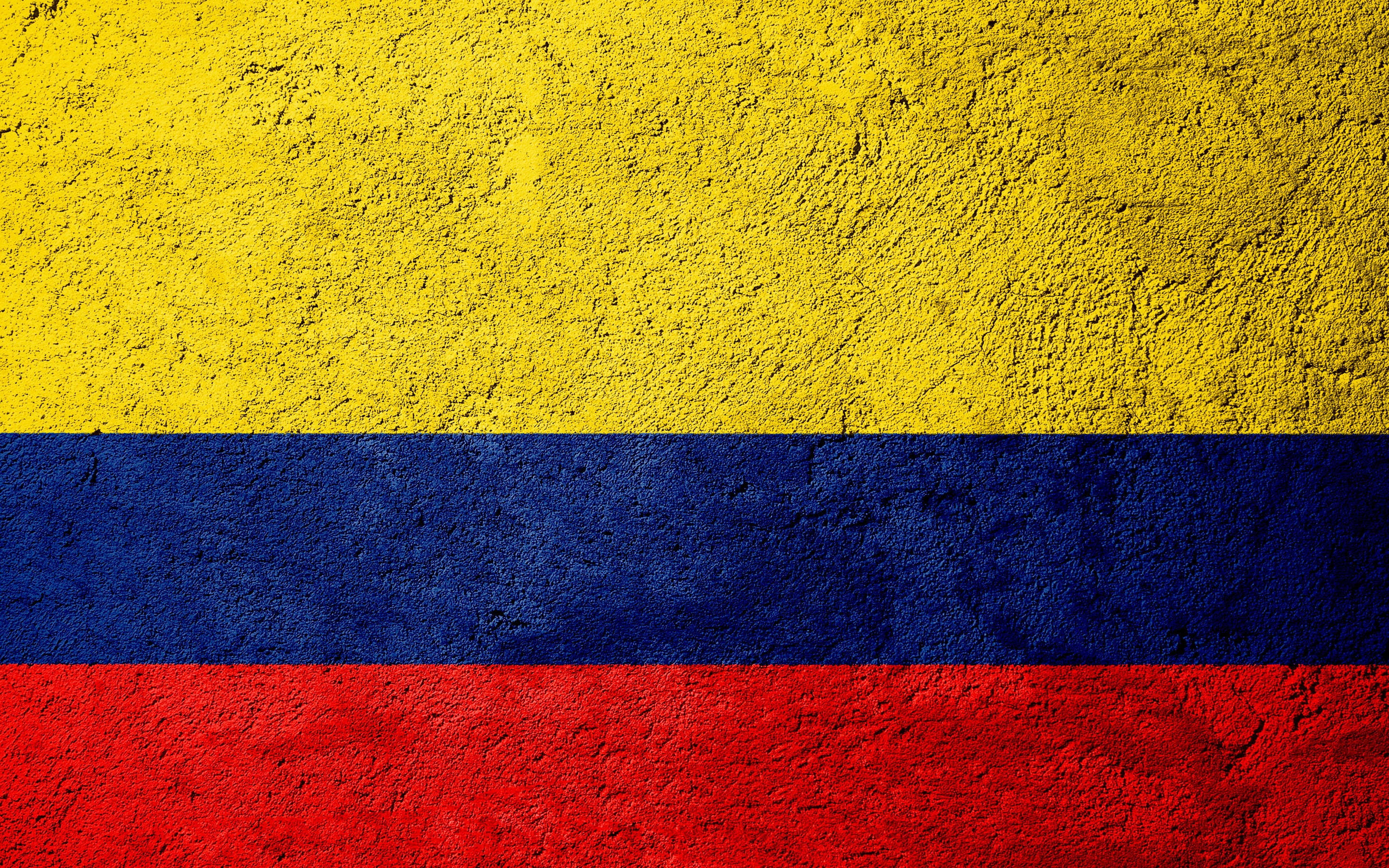 Colombia Flag 桌布 壁紙 — 哥倫比亞國旗以粗獷的水平條紋繪製在粗糙紋理的混凝土牆上。