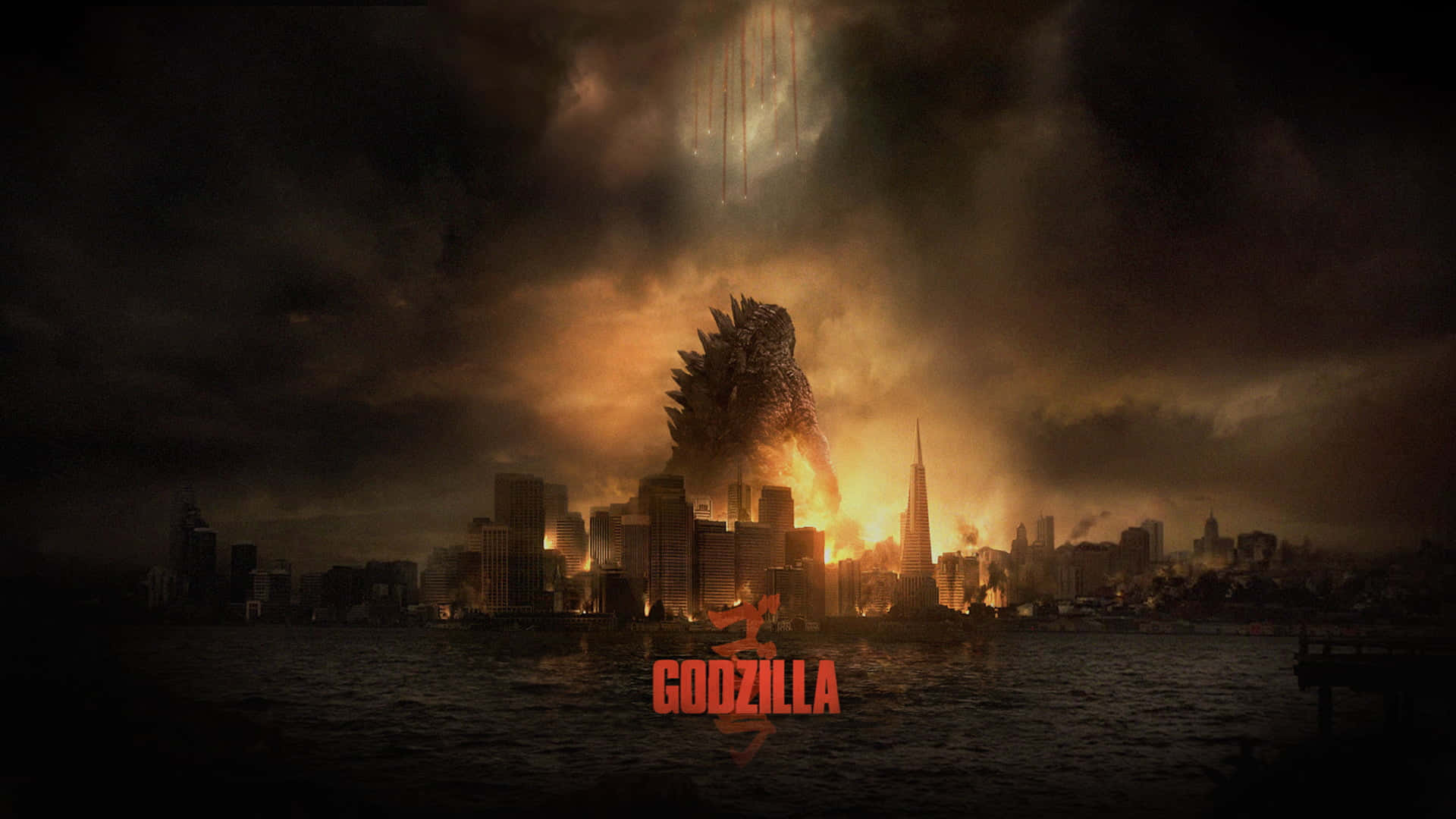 Godzilla City Destruction 桌布 壁紙 — 哥吉拉在黃昏時從燃燒的城市景觀中升起，將熾熱的橙色光芒投射在黑暗的暴風雲上。