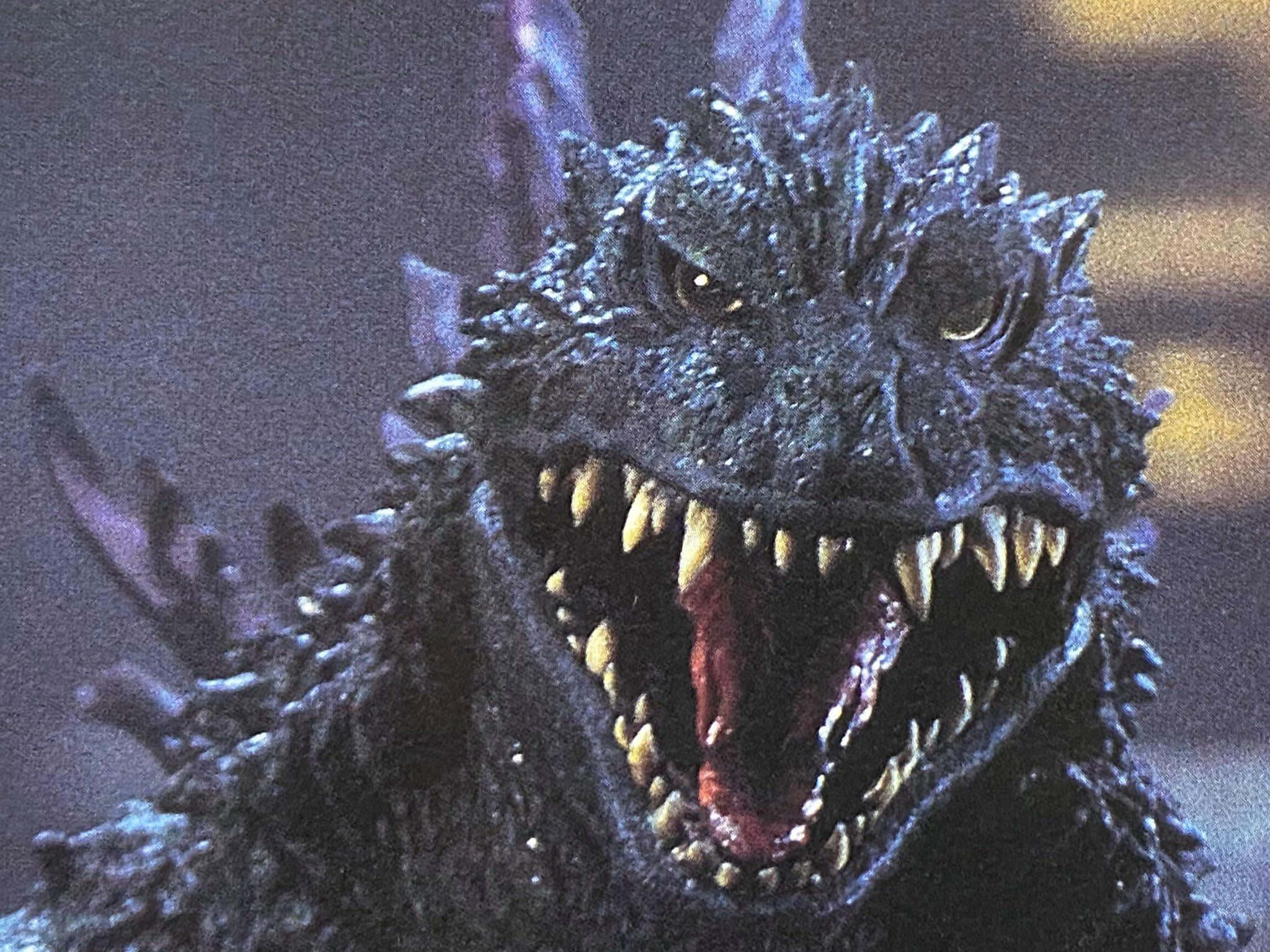 Godzilla 2000 桌布 壁紙 — 哥吉拉的近距離特寫，在黑暗煙霧背景中咆哮，眼睛發光，牙齒鋒利。