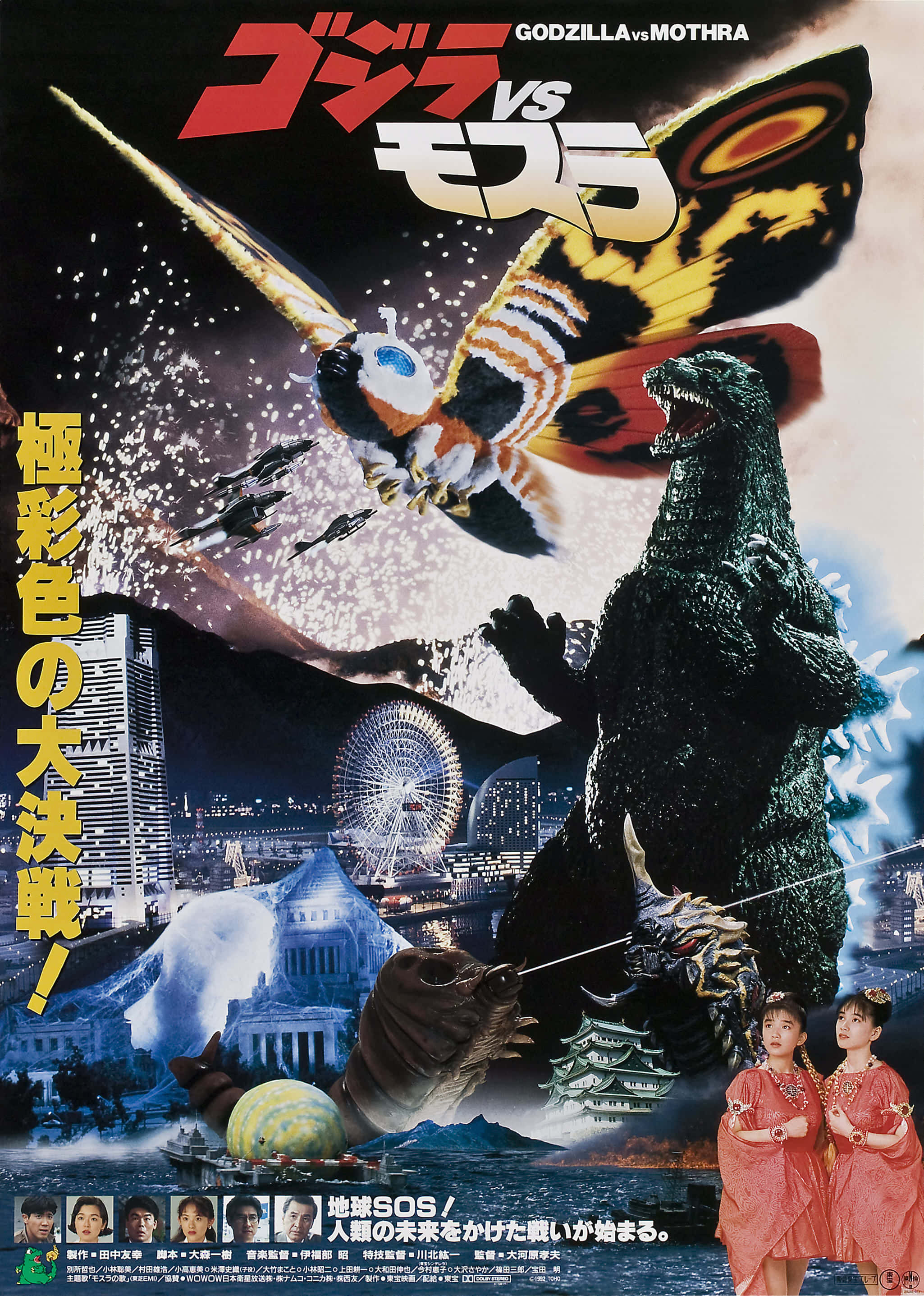 Godzilla Vs Mothra 桌布 壁紙 — 哥吉拉與摩斯拉在星空下，於有摩天輪和傳統建築的城市景觀上空交鋒。