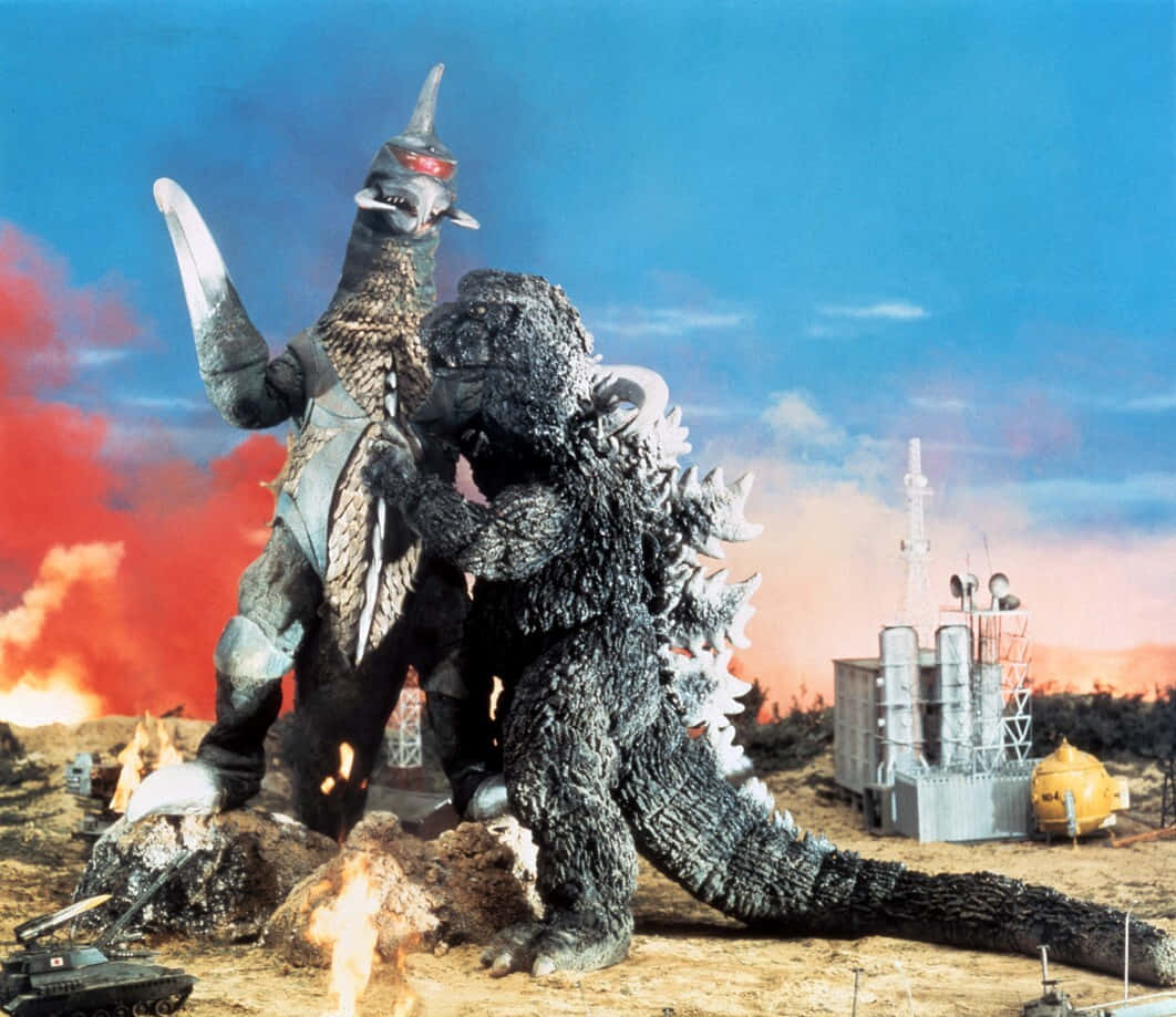 Godzilla Vs Gigan 桌布 壁紙 — 哥吉拉與王者基多拉在戲劇性的日落天空下，於熾熱爆炸與被摧毀的坦克中交鋒。
