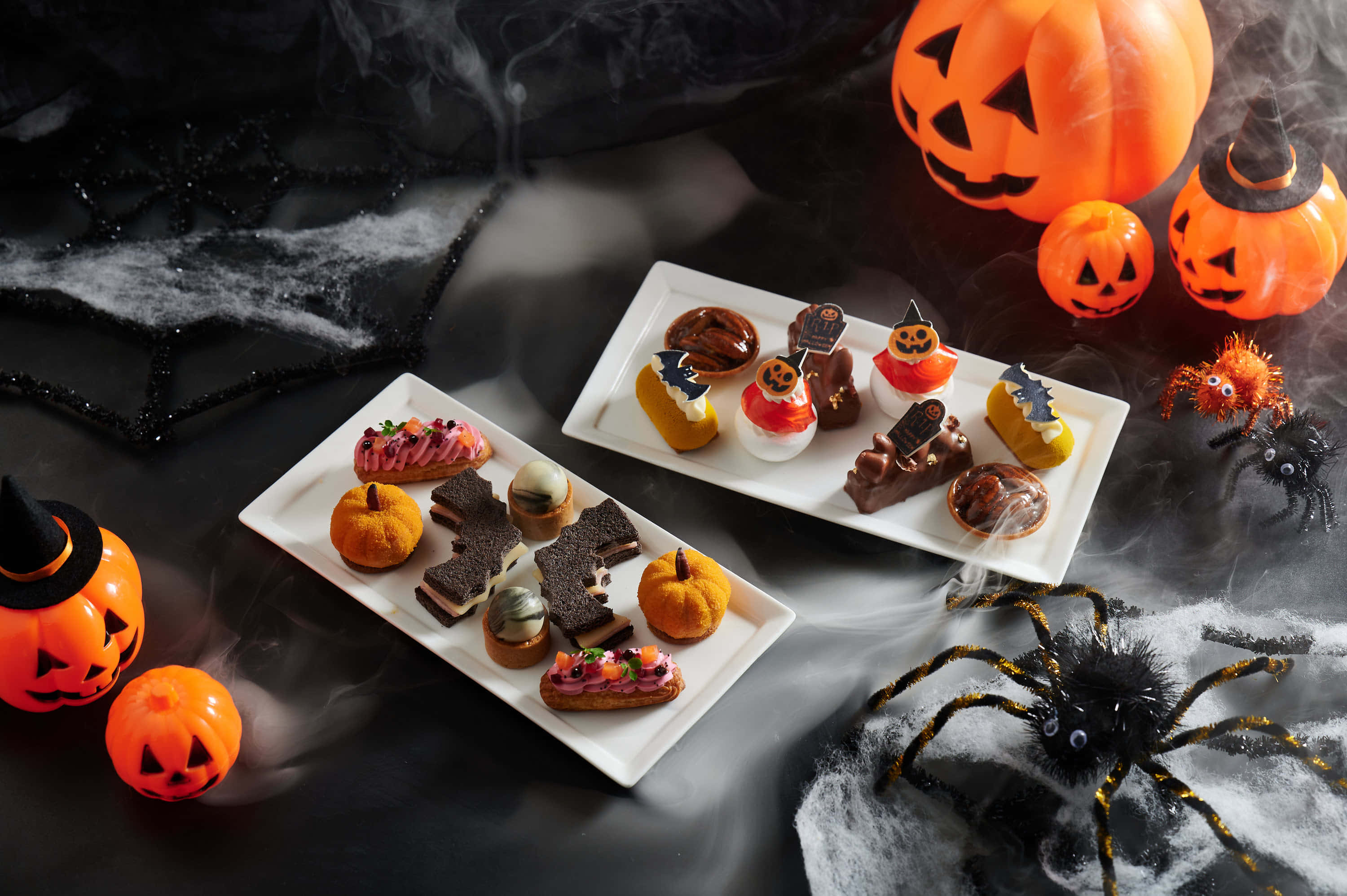 Halloween Treats 桌布 壁紙 — 哥德式萬聖節甜點拼盤，南瓜美食與發光南瓜燈籠，環繞著旋轉煙霧和蜘蛛道具。