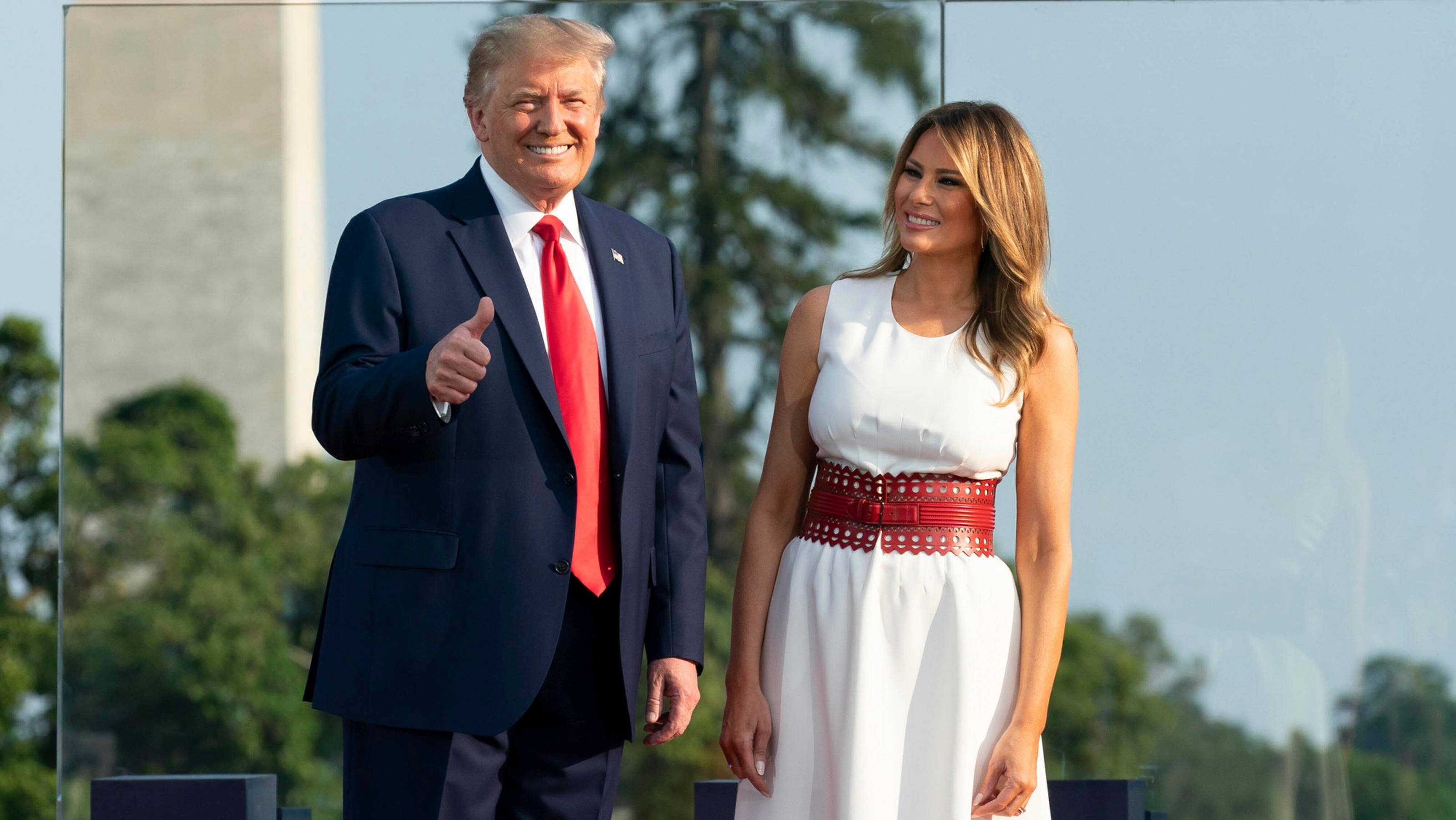 Melania 桌布 壁紙 — 唐納·川普和梅蘭妮亞·川普微笑並在戶外擺姿勢，背後可見華盛頓紀念碑。