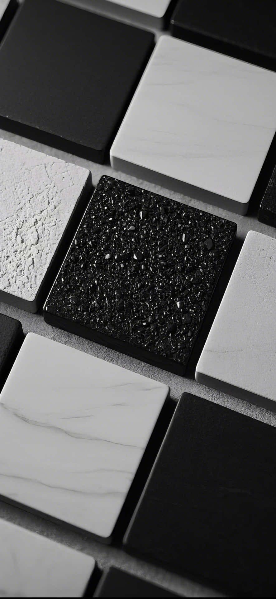 dynamic pattern of varied square tiles in subtle hues 壁紙 — 啞光黑色、亮光白色和紋理灰色的單色方形瓷磚特寫，以幾何圖案排列。