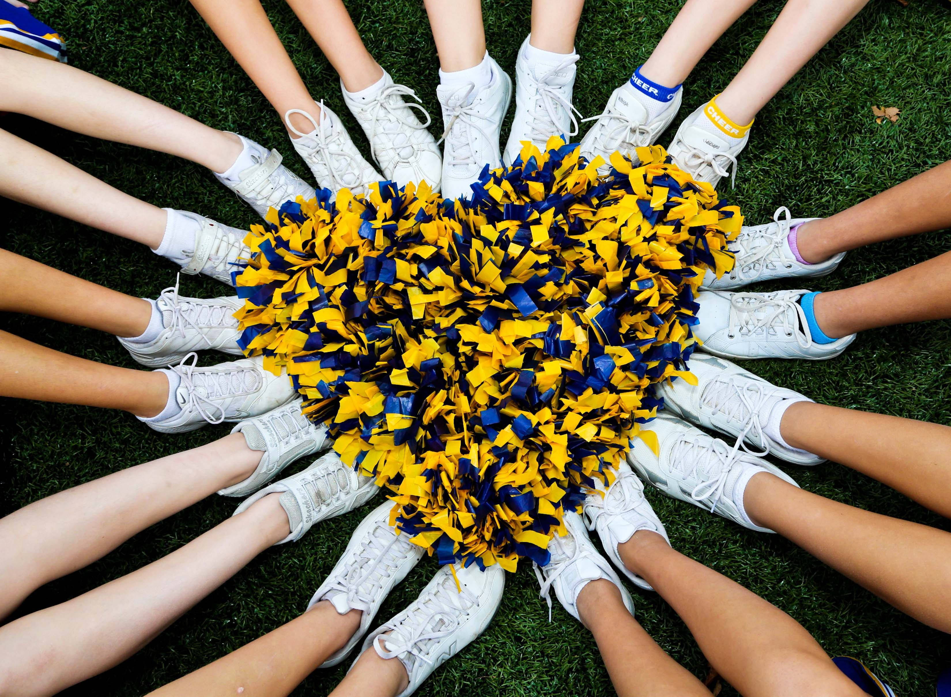 Cheerleader 桌布 壁紙 — 啦啦隊隊員穿著白色運動鞋的腿在綠色草地上圍成一個圓圈，中間是一個黃藍色的絨球心形。