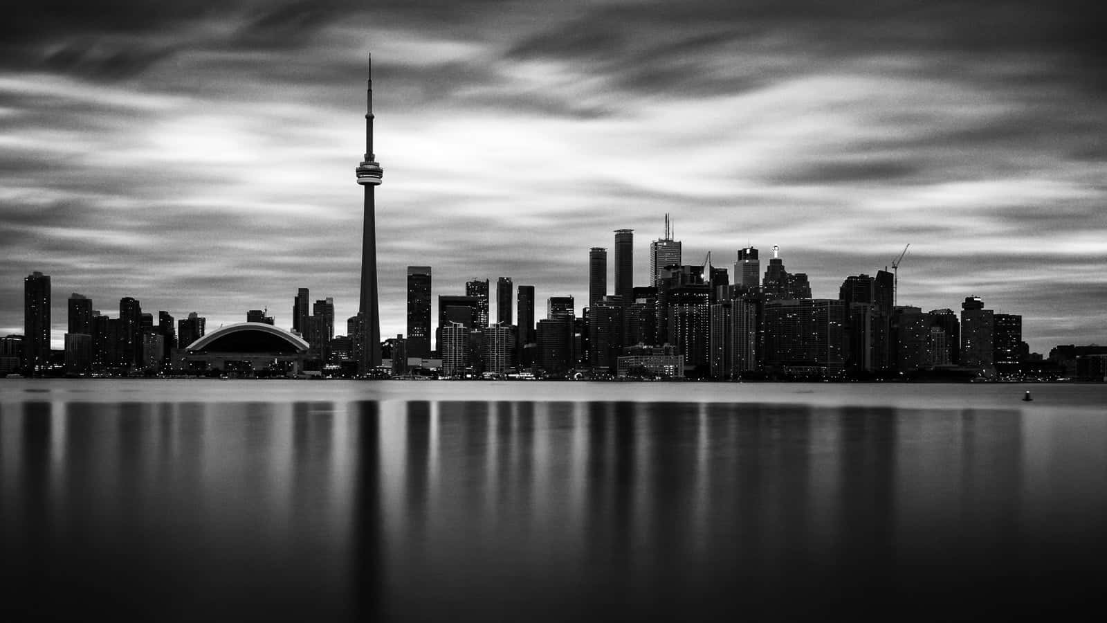 Black And White Cityscape 桌布 壁紙 — 單色城市天際線，CN 塔在平靜水面上的倒影，天空有戲劇性的雲層。