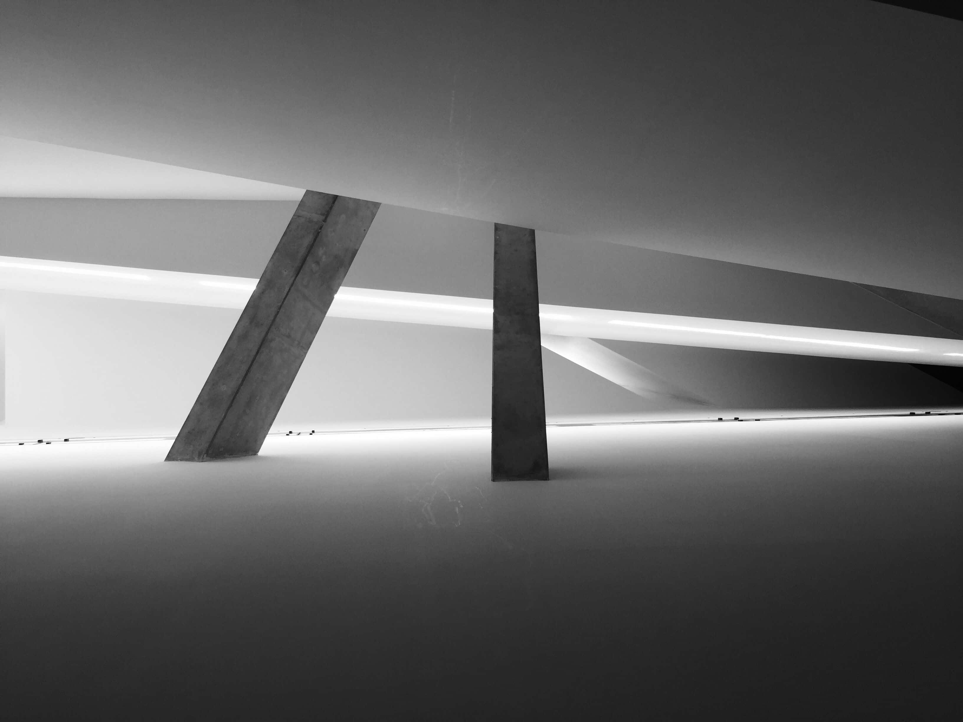 Black And White Architecture 桌布 壁紙 — 單色建築室內設計，以鮮明的混凝土柱和發光的線性燈光營造幾何陰影。