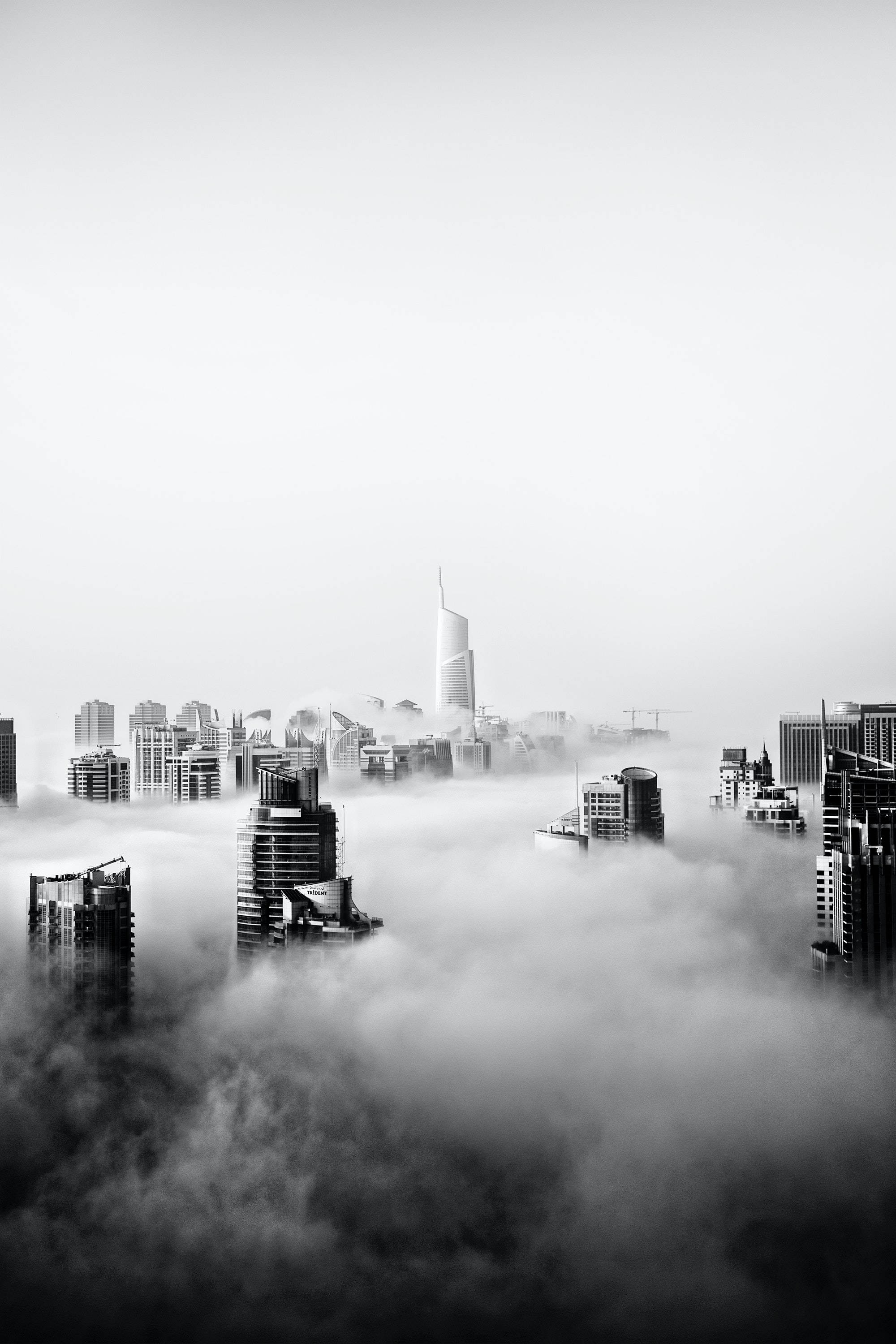 Skyscraper 桌布 壁紙 — 單色摩天大樓穿透濃霧，形成戲劇性的城市天際線。