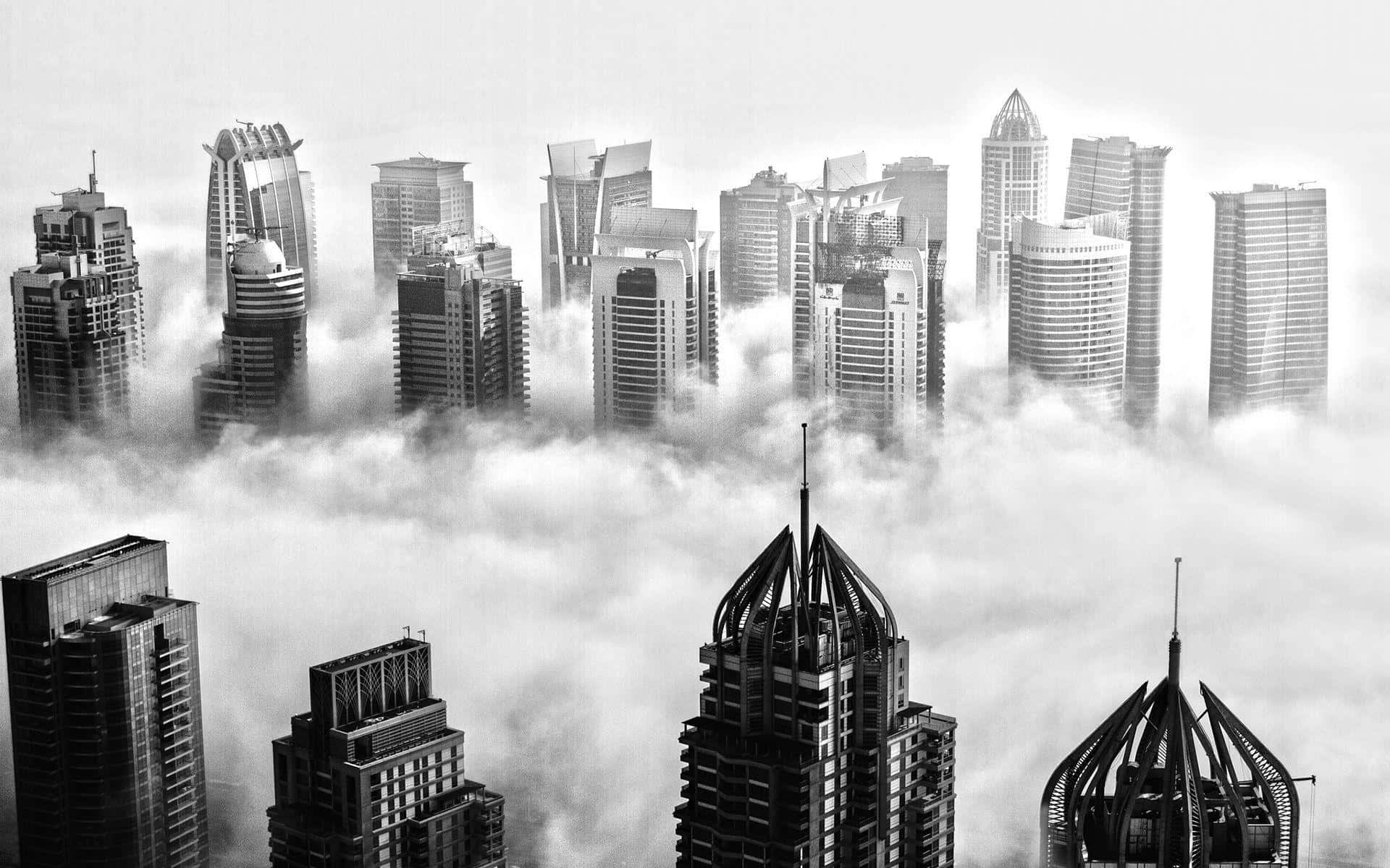 Cool Black And White 桌布 壁紙 — 單色摩天大樓穿過濃密雲層，構成戲劇性的城市天際線。