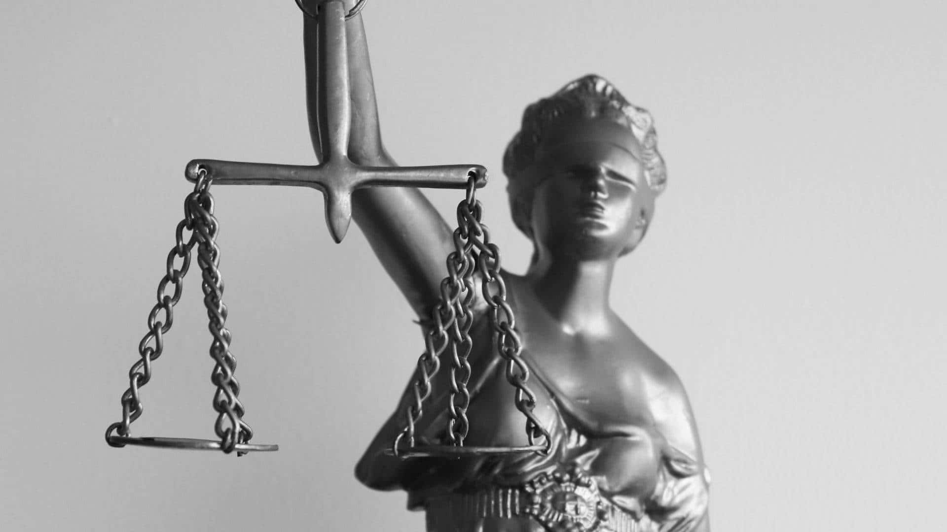 Justice 桌布 壁紙 — 單色正義女神雕像，手持天秤和劍，背景簡潔。