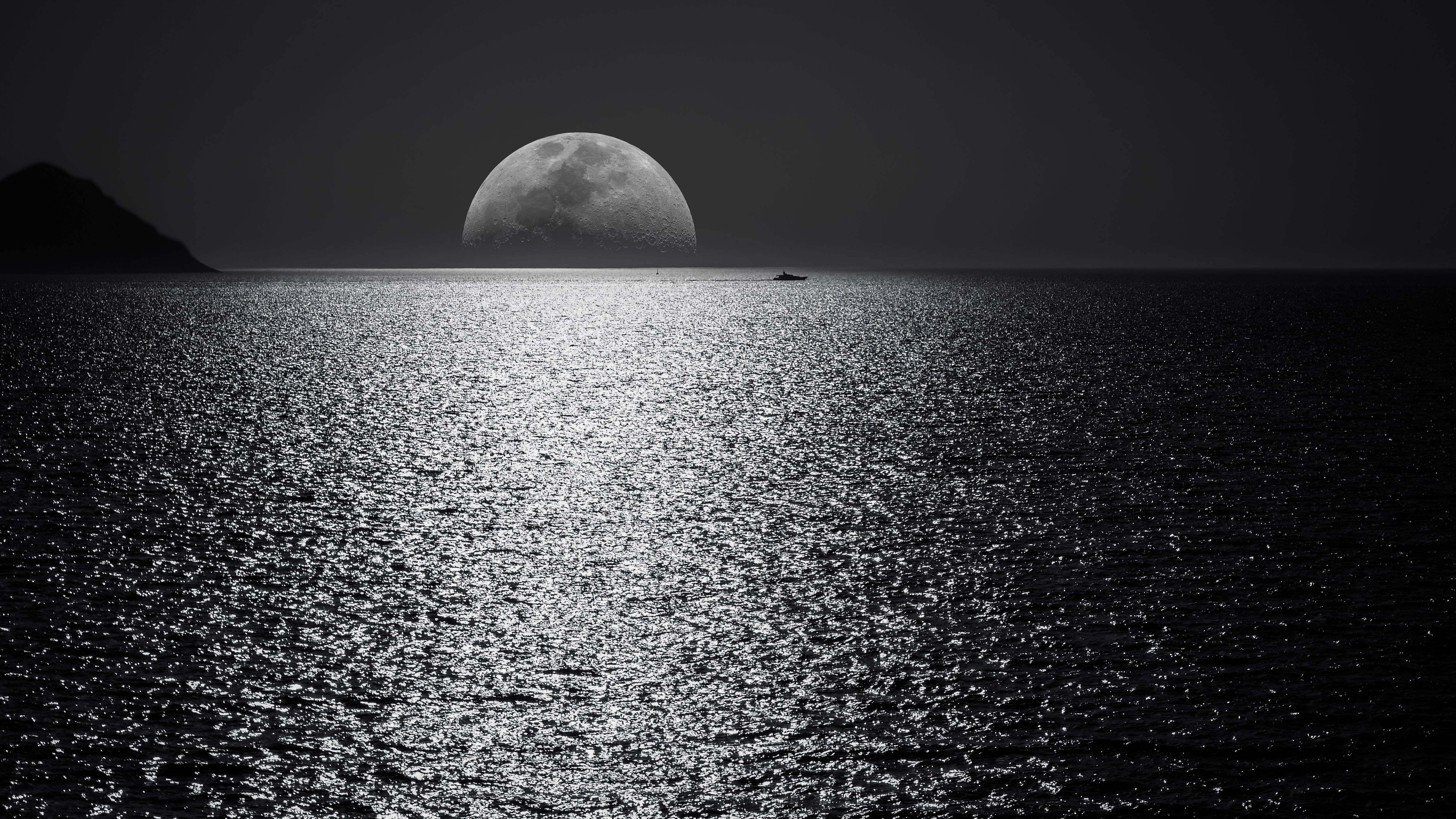 full moon 桌布 壁紙 — 單色海景，一輪巨大的月亮在平靜的水面上升起，水面反射其光芒，遠處有一艘船的剪影。