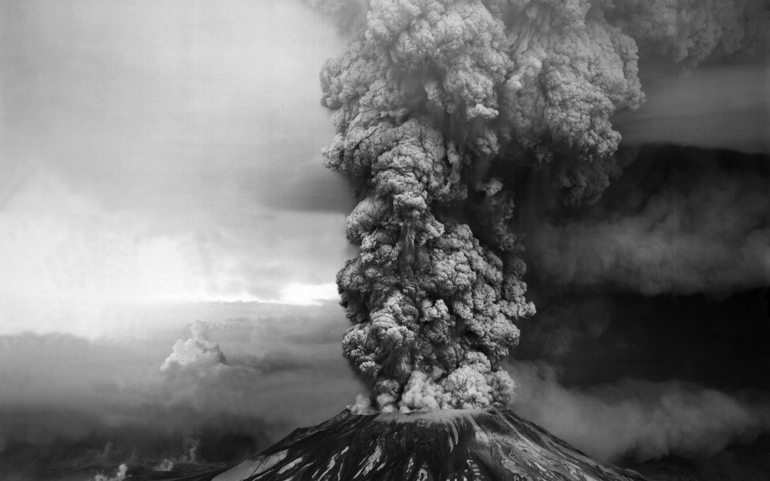 煙動圖 桌布 壁紙 — 單色火山爆發在崎嶇的山峰上，向多雲的天空噴出一股高聳的火山灰柱。
