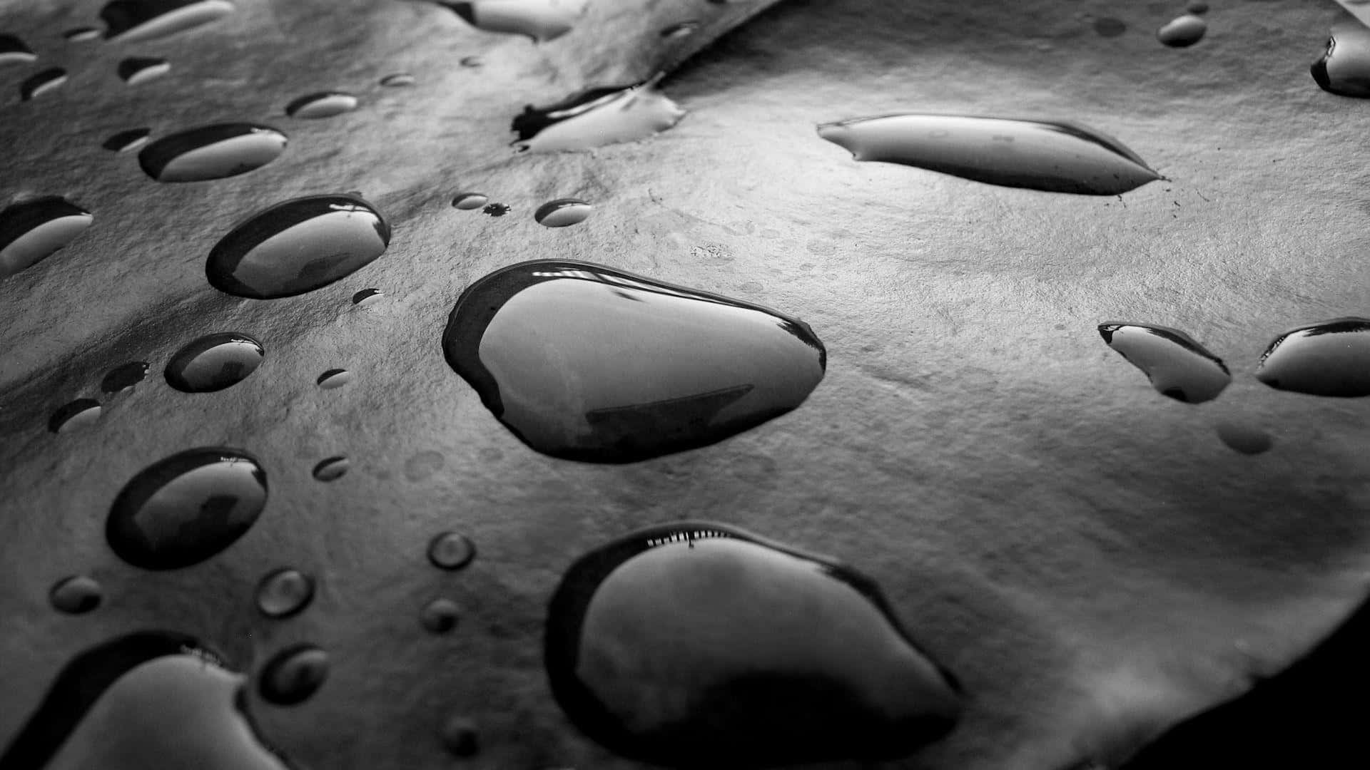 Rain Drops 桌布 壁紙 — 單色特寫，戲劇性燈光下，帶紋理的金屬表面上閃爍的雨滴。