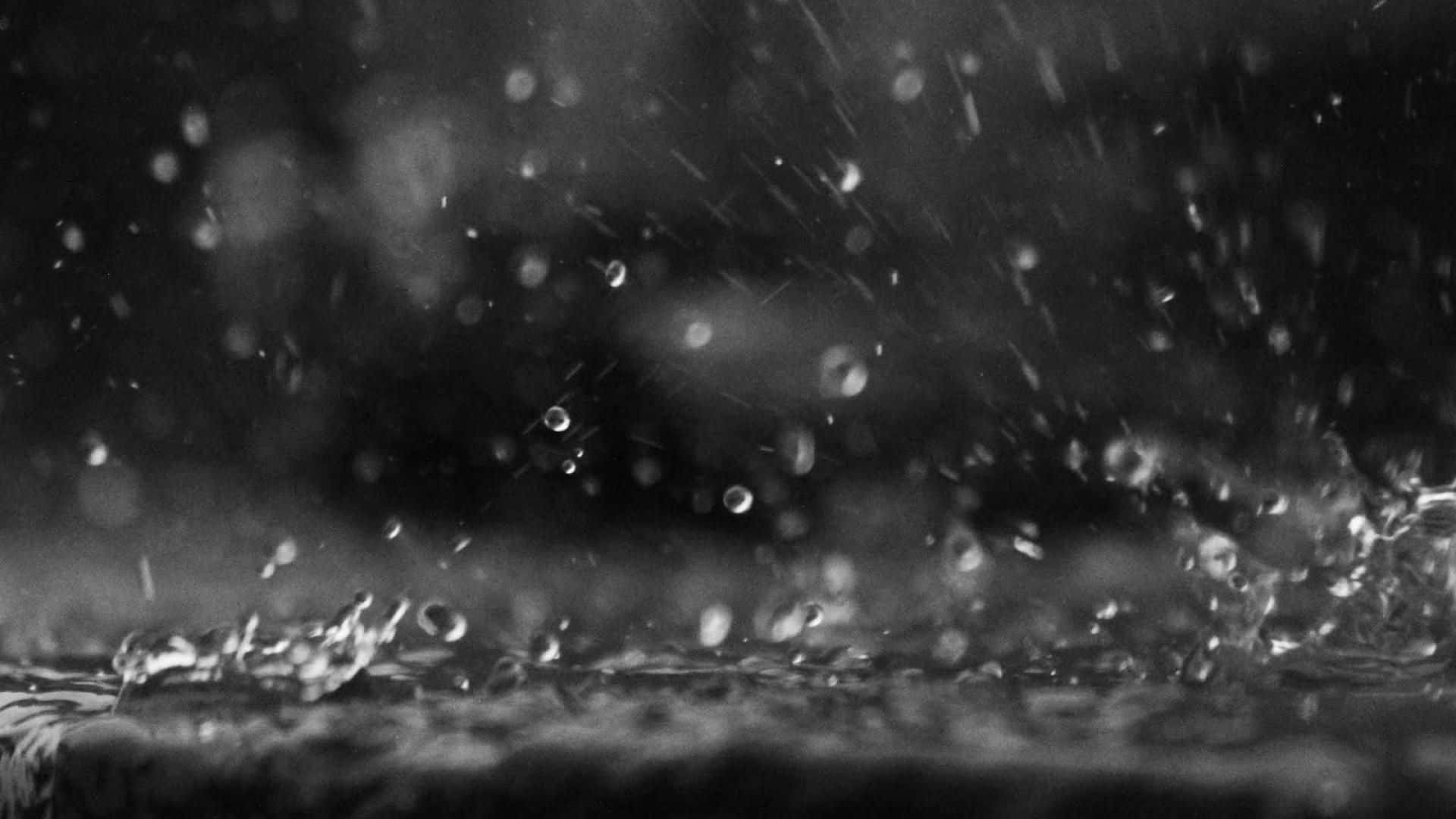 下雨 桌布 壁紙 — 單色特寫雨滴在潮濕表面上飛濺和散開，背景模糊。